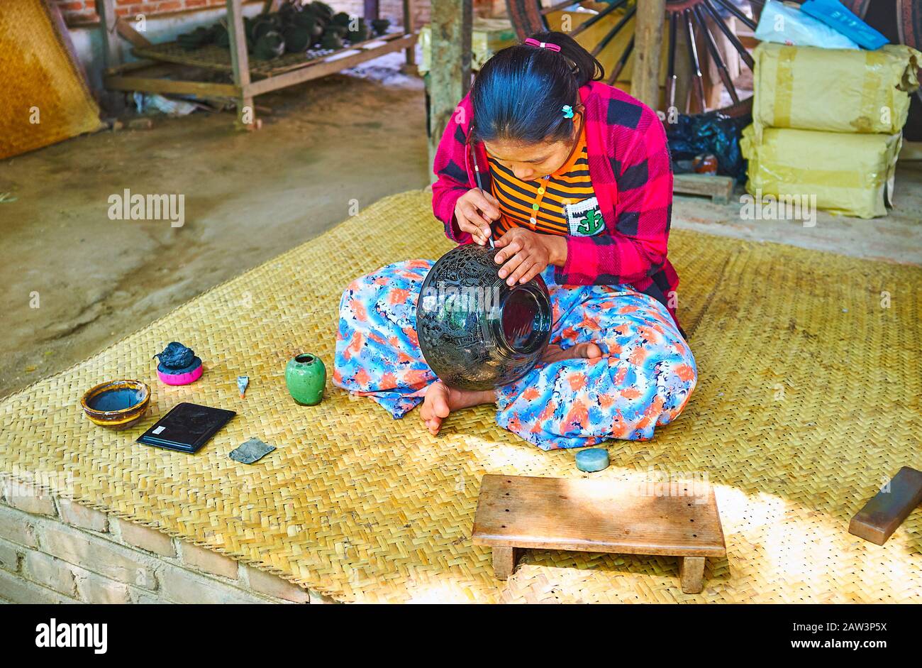 Bagan, MYANMAR - 25. FEBRUAR 2018: Der Prozess der feinen Musterung auf dekorativer Schüssel, mit schwarzem Lack in authentischen Lackarbeiten überzogen Stockfoto