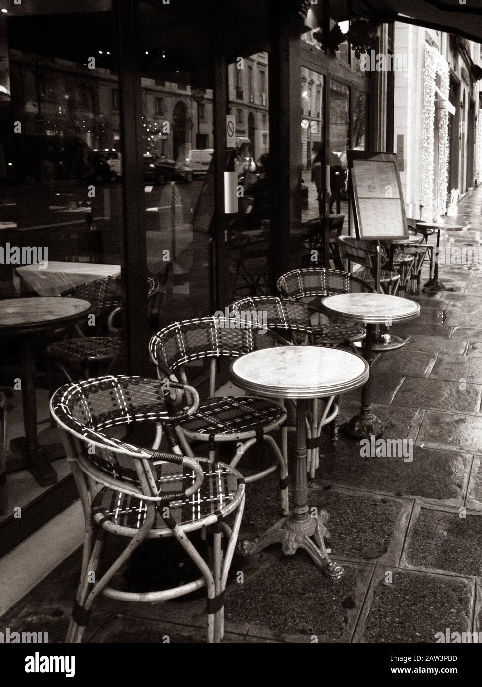 Paris, Frankreich, Pariser Café, Tische und Stühle auf gepflastertem Bürgersteig, Schwarz-Weiß-Foto. Stockfoto