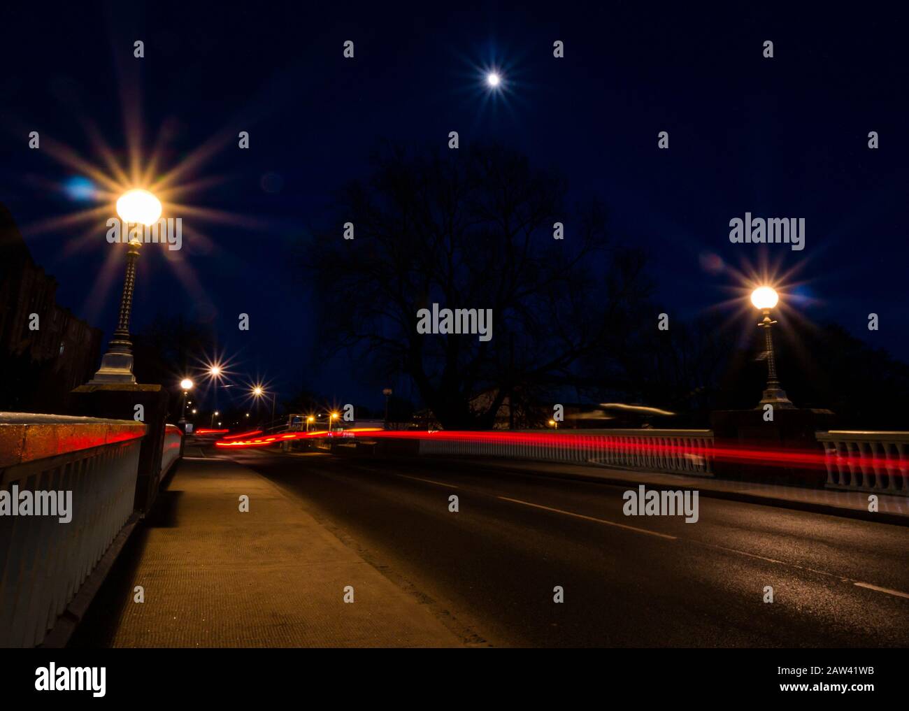 Haddington, East Lothian, Schottland, Großbritannien. Februar 2020. Wetter in Großbritannien: Ein schwindelerregende, schwungvolle Mond bei 91,4 % heute Abend in einem klaren Himmel über der aufgeführten Victoria Bridge mit Pkw-Lichtwegen Stockfoto