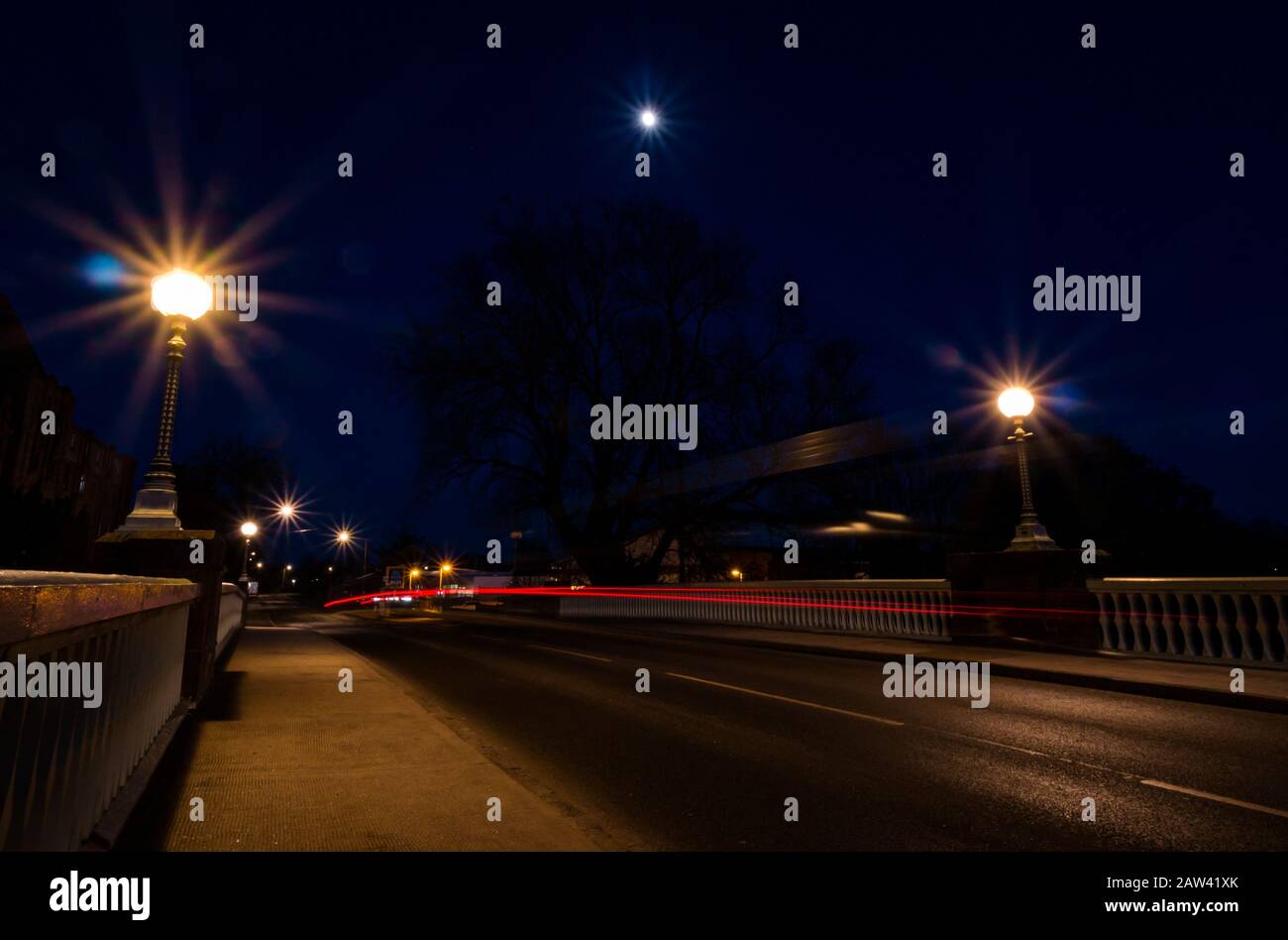 Haddington, East Lothian, Schottland, Großbritannien. Februar 2020. Wetter in Großbritannien: Ein schwindelerregende, schwungvolle Mond bei 91,4 % heute Abend in einem klaren Himmel über der aufgeführten Victoria Bridge mit Pkw-Lichtwegen Stockfoto