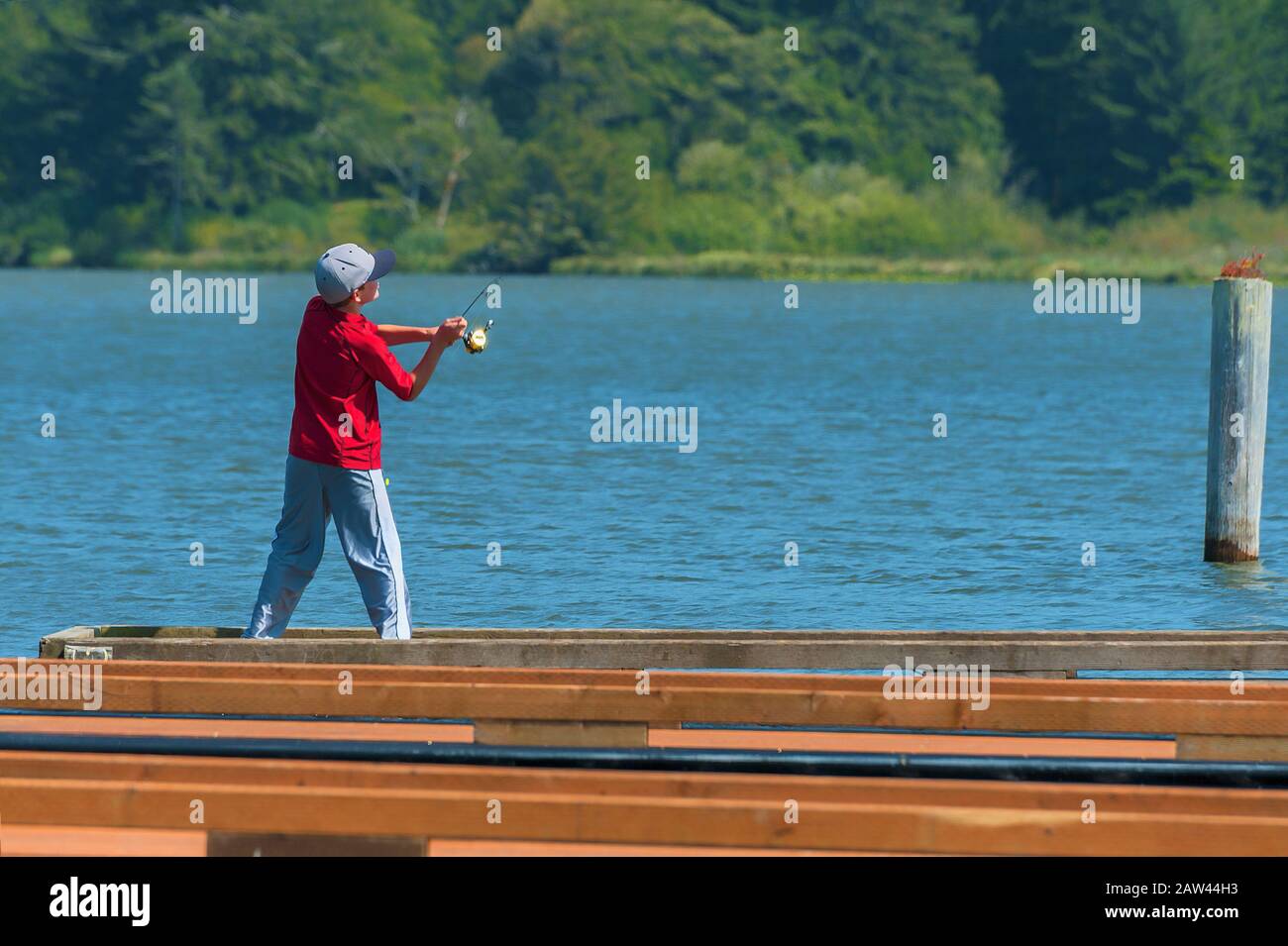 Kleiner Junge, der am Devils Lake in Lincoln City, Oregon vor dem Dock angeln kann Stockfoto