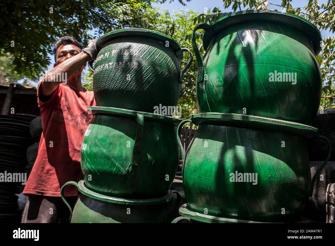 Die Arbeiter sahen am Donnerstag, den 15. August 2019, in der Werkstatt "Einkaufszentrum und Medium Enterprise" (UKM) in Palu, Zentral-Sulawesi, Indonesien, Abfallbehälter aus gebrauchten Reifenabfällen anfertigen. Verschiedene Kunsthandwerke aus gebrauchten Reifenabfällen werden zu Preisen zwischen 75 und 200 Tausend Rupiah verkauft. Gebrauchte Reifenabfälle können verwendet werden, um wirtschaftliche Wertgegenstände wie Bänke, Tische oder Weiterverarbeitung zu Gummipulver zu fertigen. Stockfoto