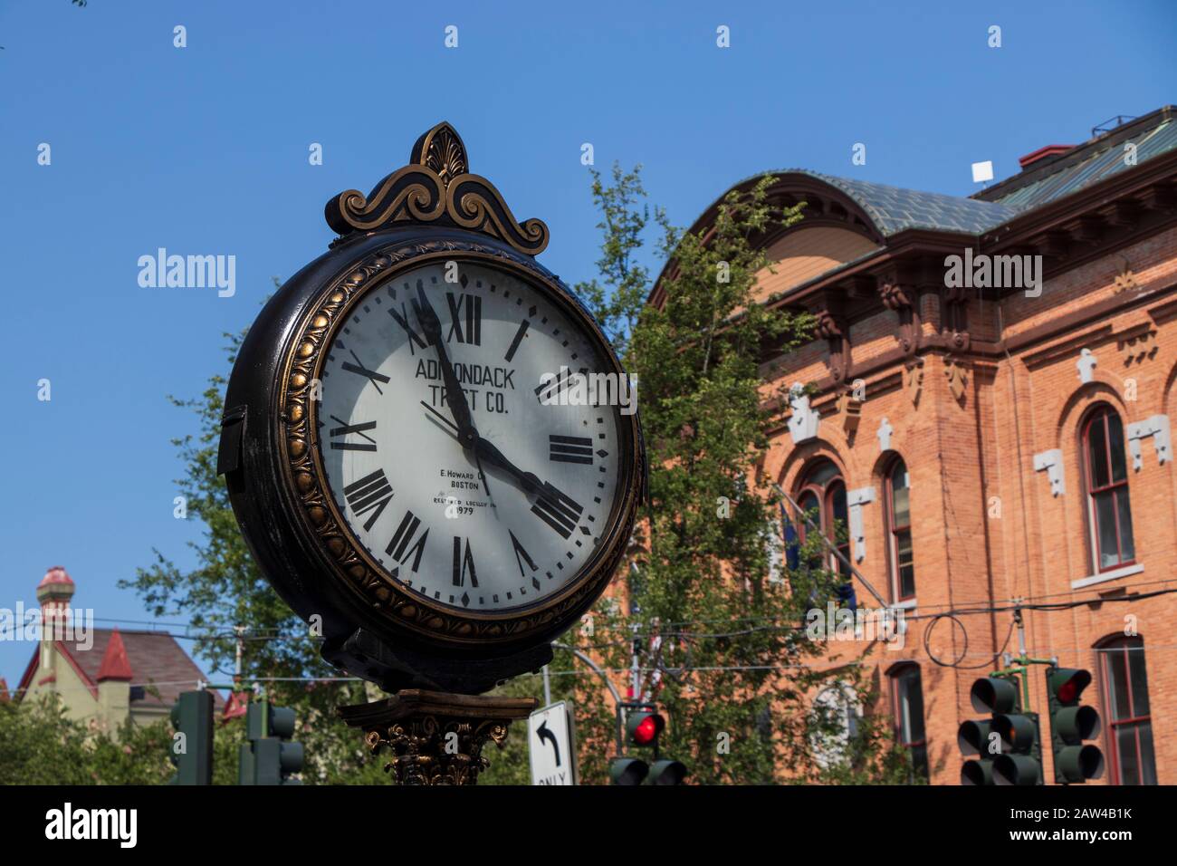 August 2019 : Uhr am Broadway St und Red Brick Building Hintergrund in Downtown Saratoga Springs, Historisches Viertel, NY, USA Stockfoto