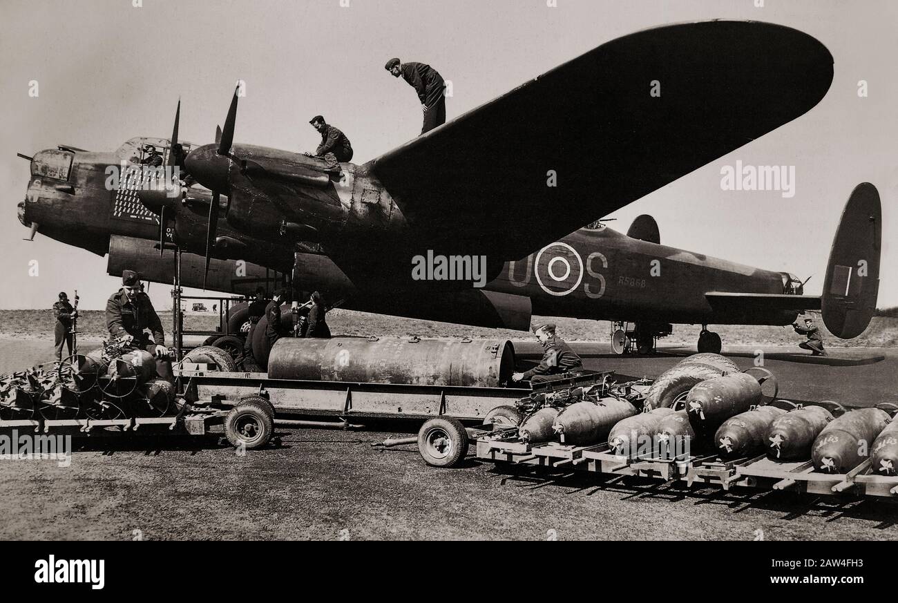 RAF Ground Crew, die einen schweren Bomber vom Typ Avro Lancaster, British Second World war, von 467 (RAAF) Squadron I mit 4.000 Pfund und 500 Pfund schweren Bomben mittlerer Kapazität beladen. Der lange, ungehinderte Bombenschacht des Flugzeugs bedeutete, dass die Lancaster die größten von der RAF verwendeten Bomben aufnehmen konnte, darunter die Blockbuster 4.000 lb (1.800 kg), 8.000 lb (3.600 kg) und 12.000 lb (5.400 kg), Lasten, die oft mit kleineren Bomben oder Brandstiften ergänzt wurden. Die "LANC", wie sie in der Kolloquie bekannt war, wurde zu einem der am stärksten genutzten Nachtbomber des Zweiten Weltkriegs. Stockfoto