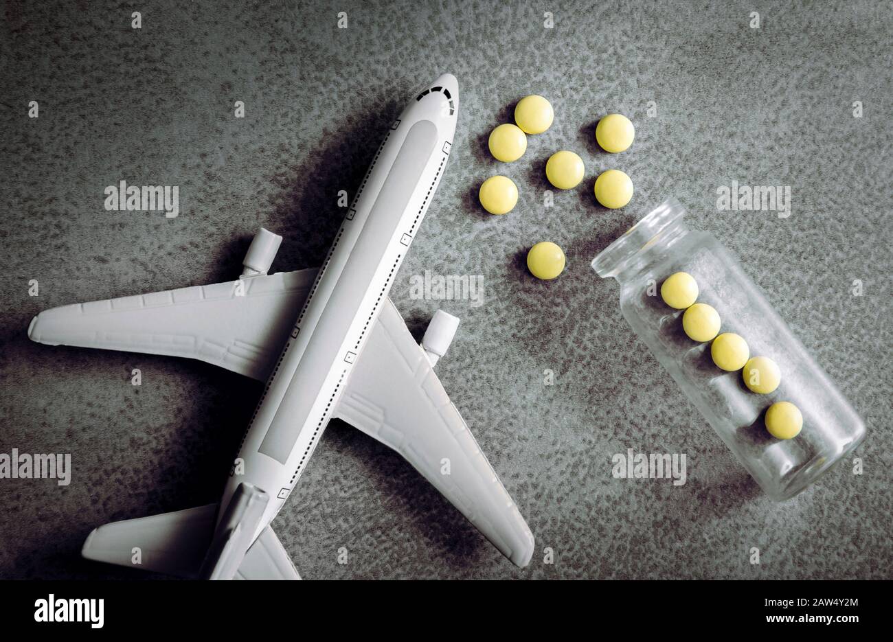 Planfigur mit verschütteten Pillen. Reise- und Medizinkonzept. Flacher Laienblick mit Kopierbereich auf minimalistischem grauem Hintergrund. Stockfoto