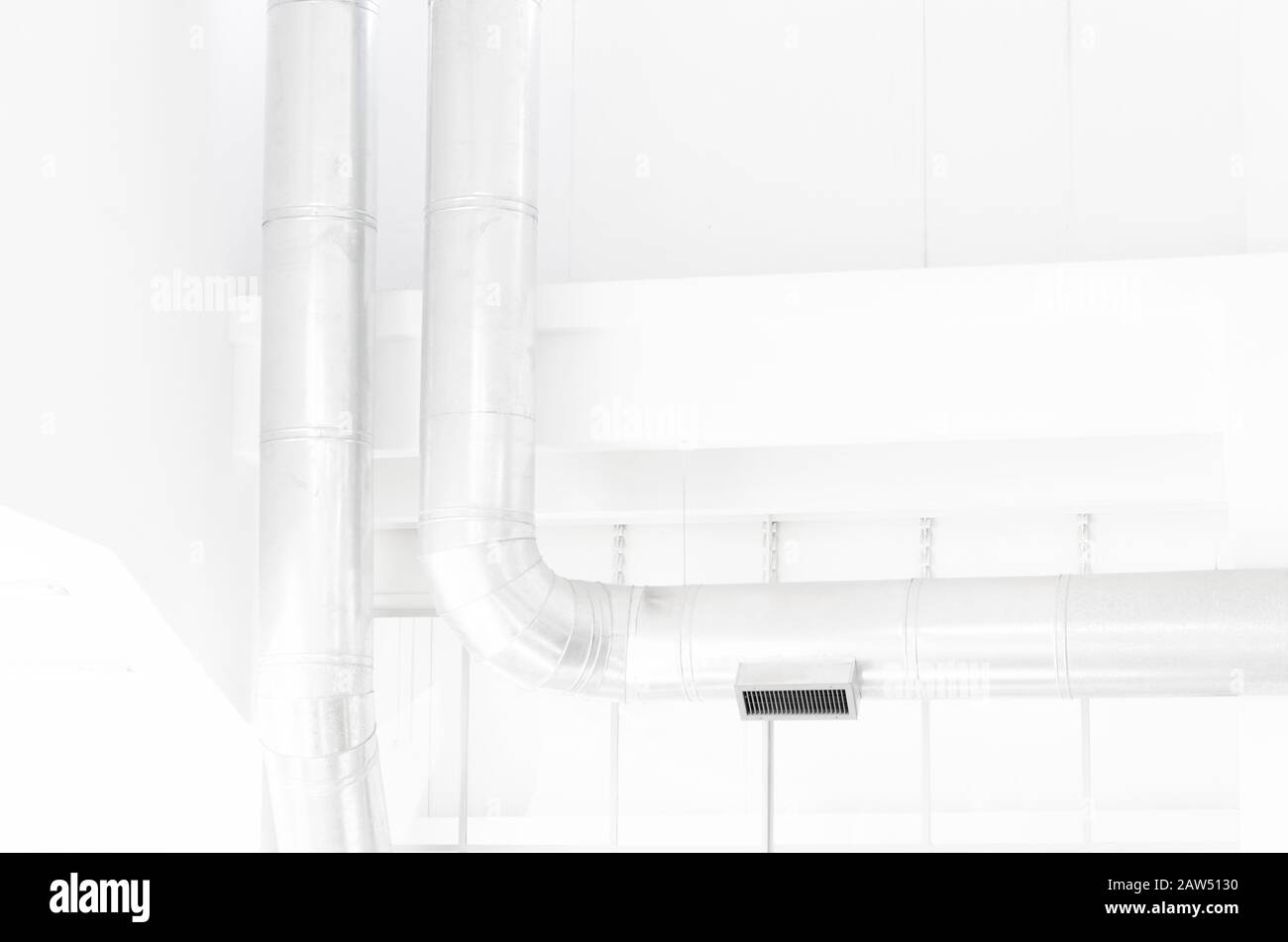 Industrielle moderne Architektur: Interieur in hellen Farben, weiße Wände und silberne Rohre Stockfoto