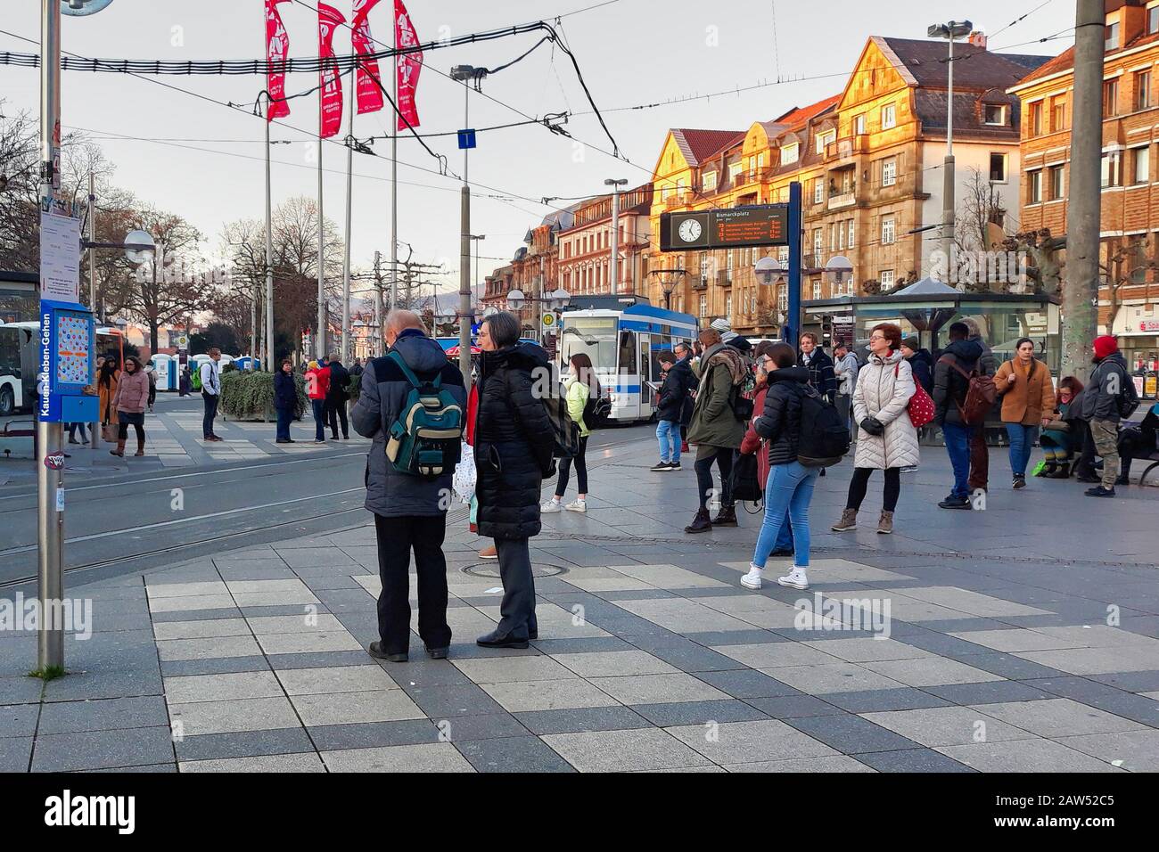 Am "Bismarkplatz" in Heidelberg halten die Leute am Regenweg und die öffentlichen Verkehrsmittel Stockfoto