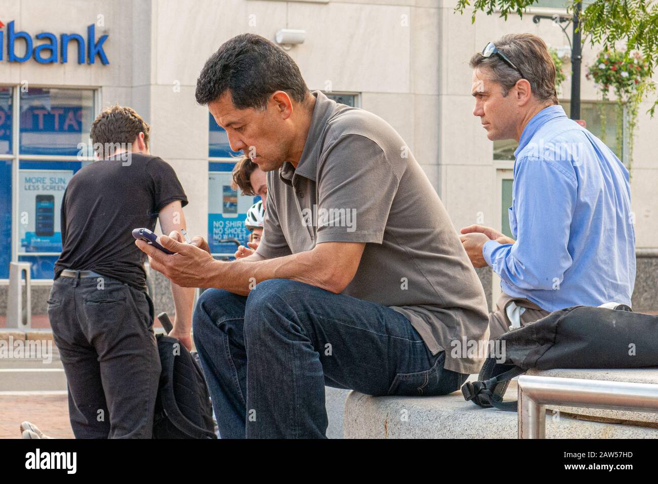 Ein Mann auf dem Harvard Square mit seinem Handy Stockfoto