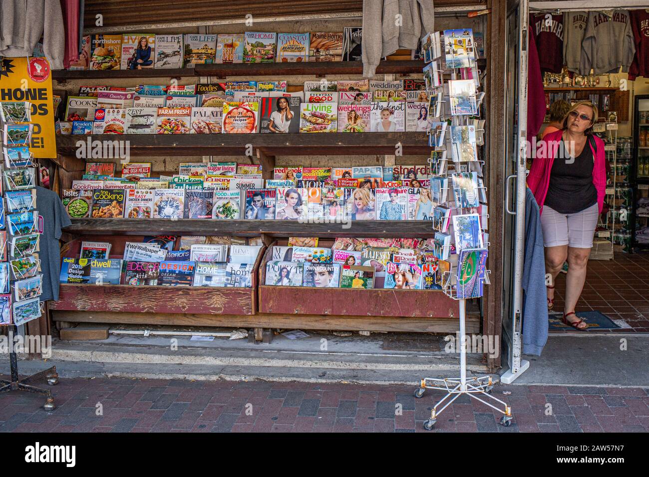 Eine Frau verlässt einen Laden, in dem Zeitschriften und Zeitungen auf dem Harvard Square verkauft werden Stockfoto