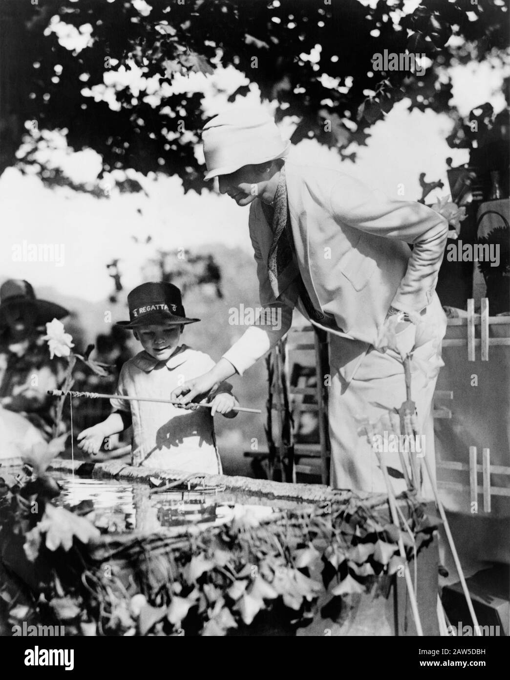 1926, 21. Mai, Washington, USA: Madame Luciano Mascia hilft einem Kind an einem künstlichen Fischteich auf der Garden Party bei Twin Oakes, dem Anwesen von Stockfoto