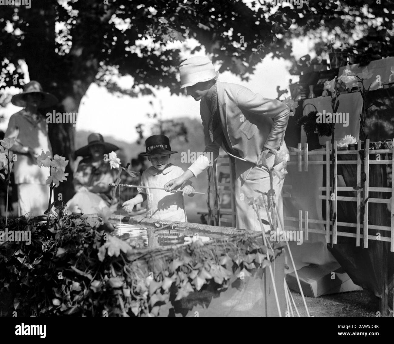 1926, 21. Mai, Washington, USA: Madame Luciano Mascia hilft einem Kind an einem künstlichen Fischteich auf der Garden Party bei Twin Oakes, dem Anwesen von Stockfoto