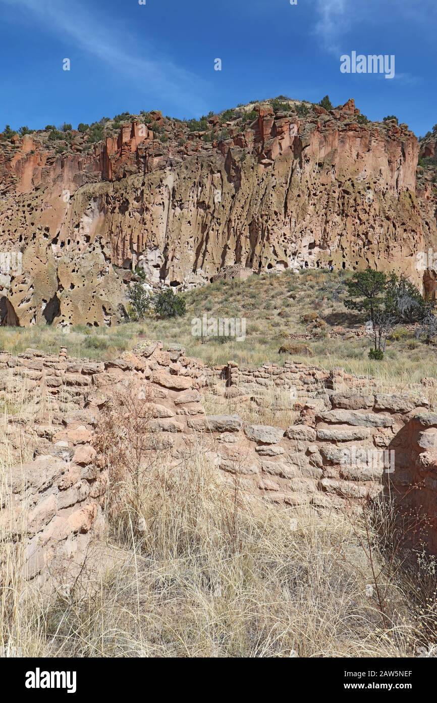 Teil der Tyuonyi-Ruinen der angestammten Pueblo-Völker mit einem rekonstruierten Pueblo an den Klippen entlang des Hauptschleifenweges im Frijoles Canyon bei Ba Stockfoto