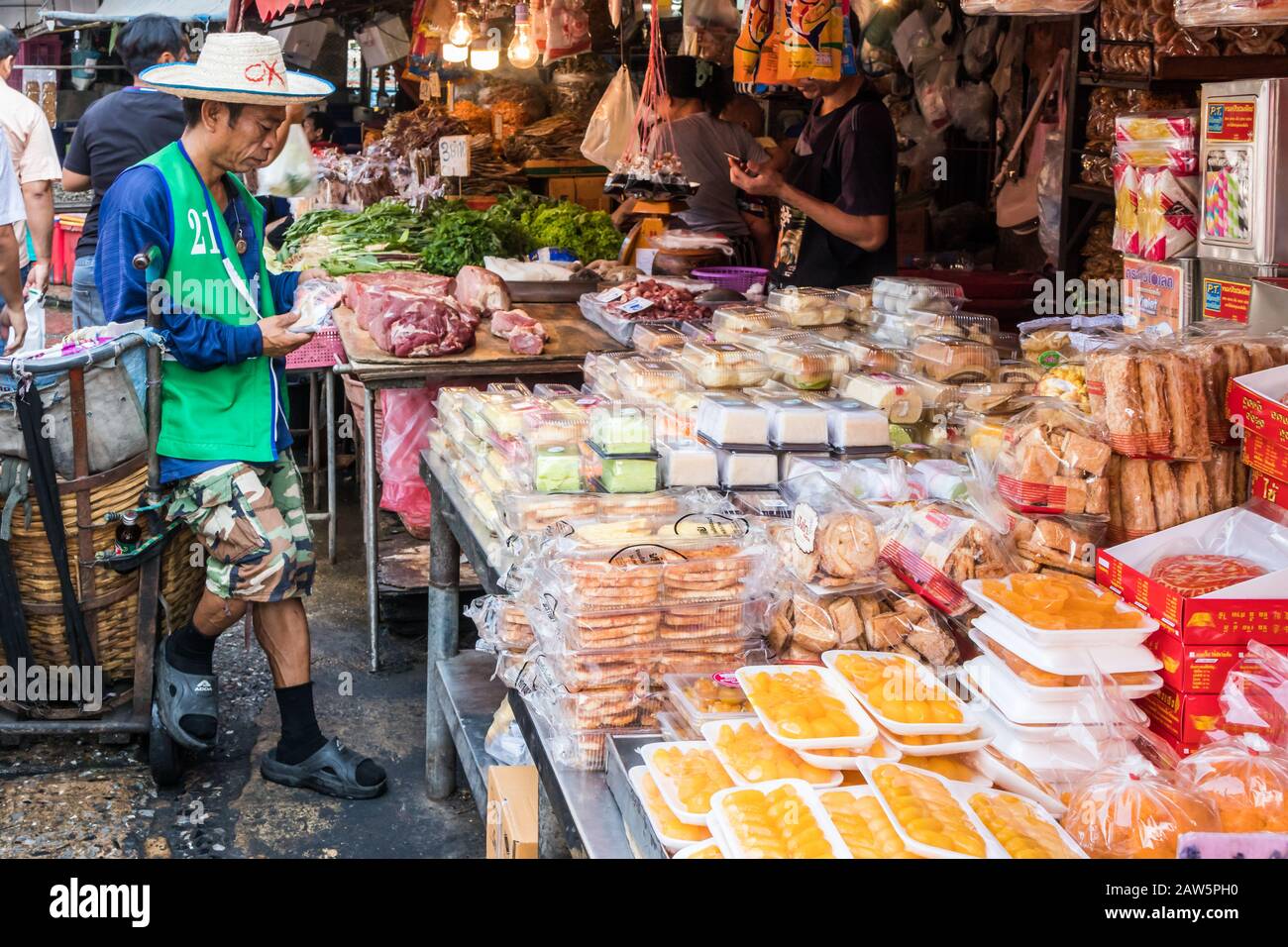 Bangkok, Thailand - 9. Januar 2020: Portier wartet auf einen Lebensmittel-Stall auf dem Khlong Toei Wet Market. Dies ist der größte Nassmarkt der Stadt. Stockfoto