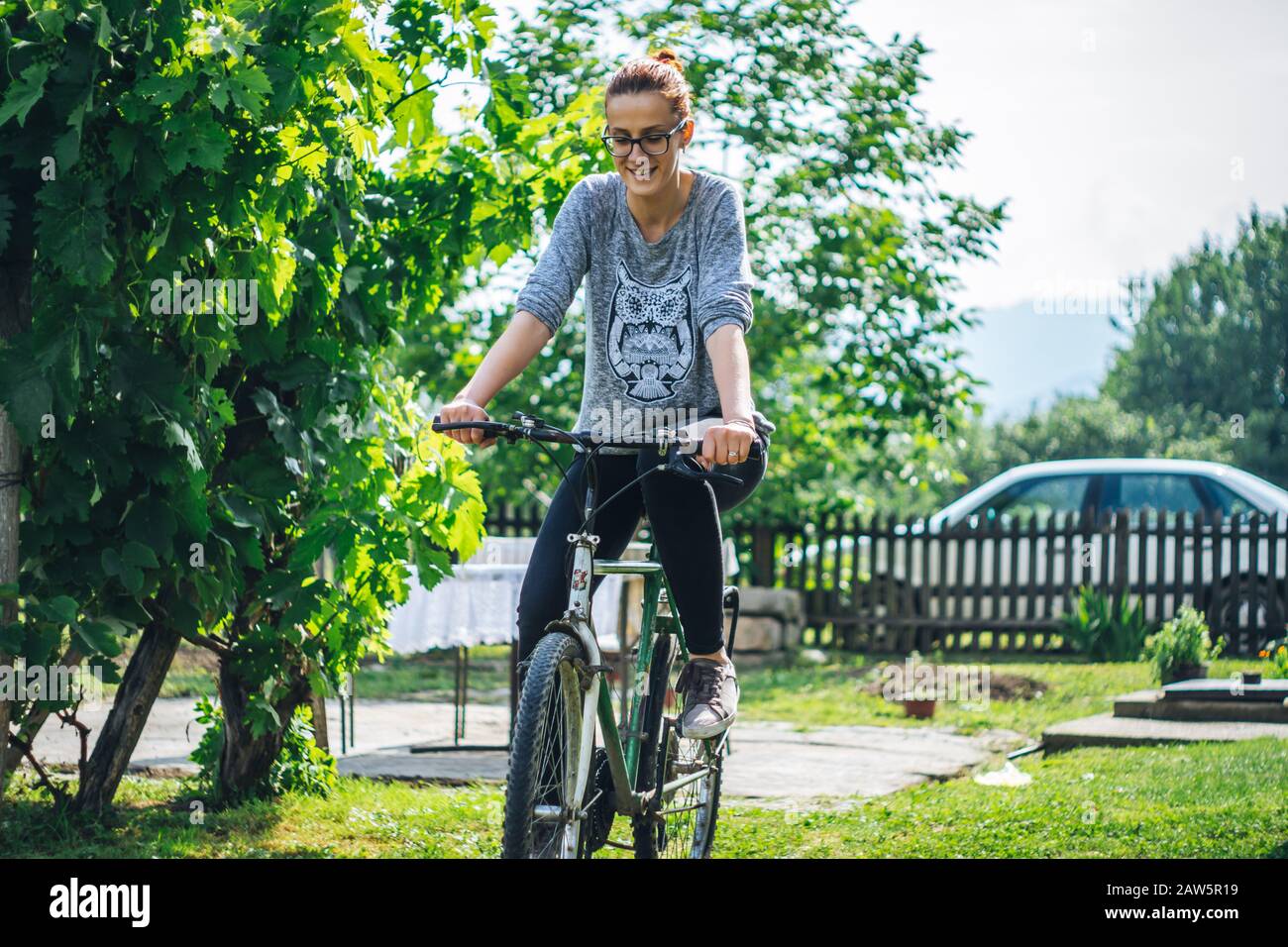 Frau, die auf einem Bauernhof mit dem Fahrrad unterwegs ist Stockfoto