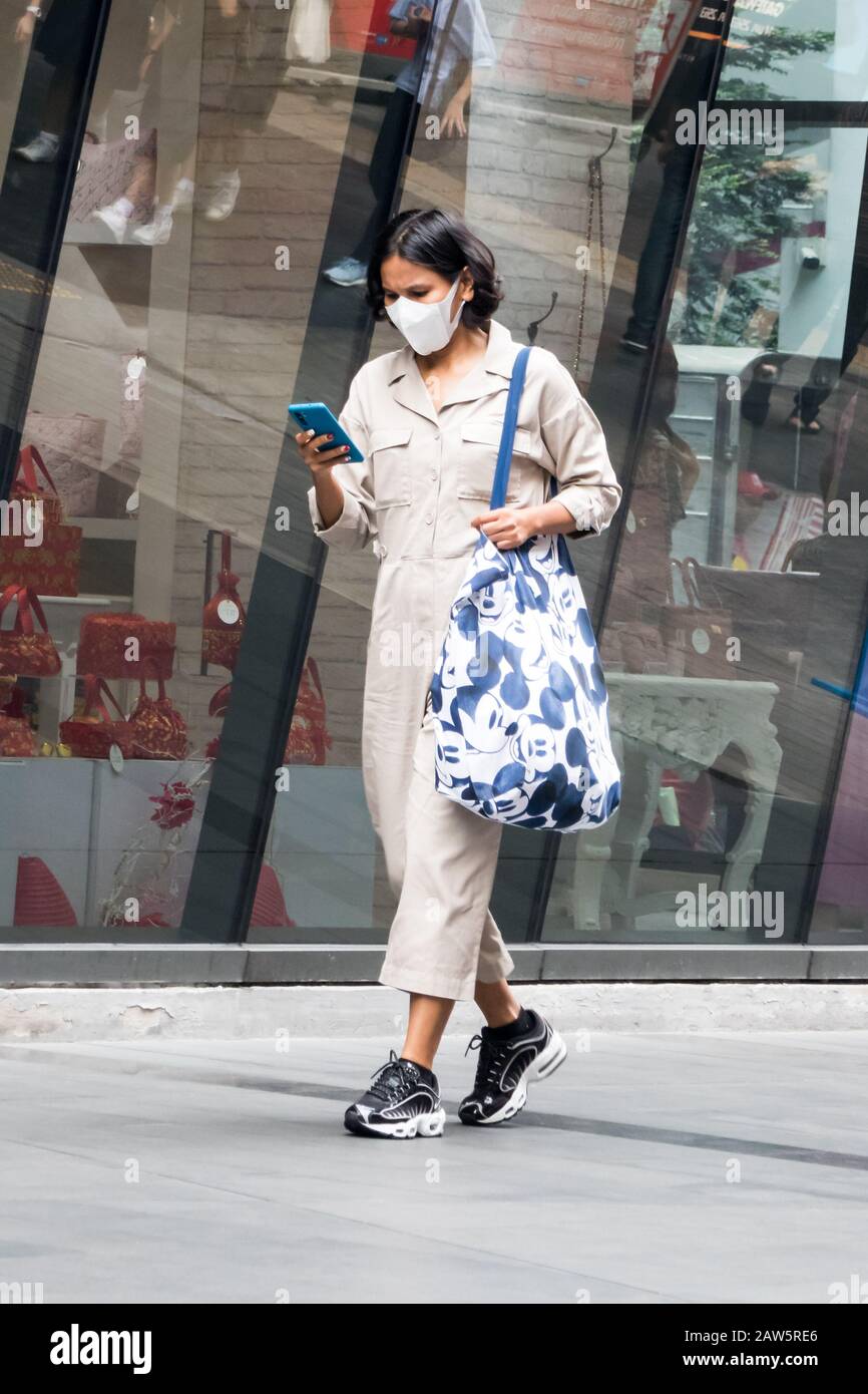 Bangkok, Thailand - 10. Januar 2020: Frau mit Gesichtsmaske zum Schutz vor Smog und Coronavirus. Die Stadt wurde von Smog in geplagt Stockfoto
