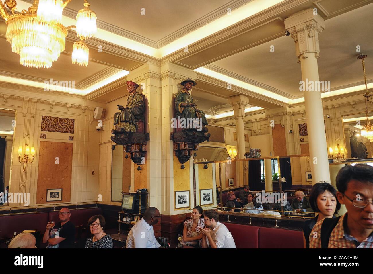 In dem berühmten Schriftstellercafé Les Deux Magots, Kunden, die zwei Skulpturen von zwei chinesen; nun, es war eine andere Zeit. Stockfoto