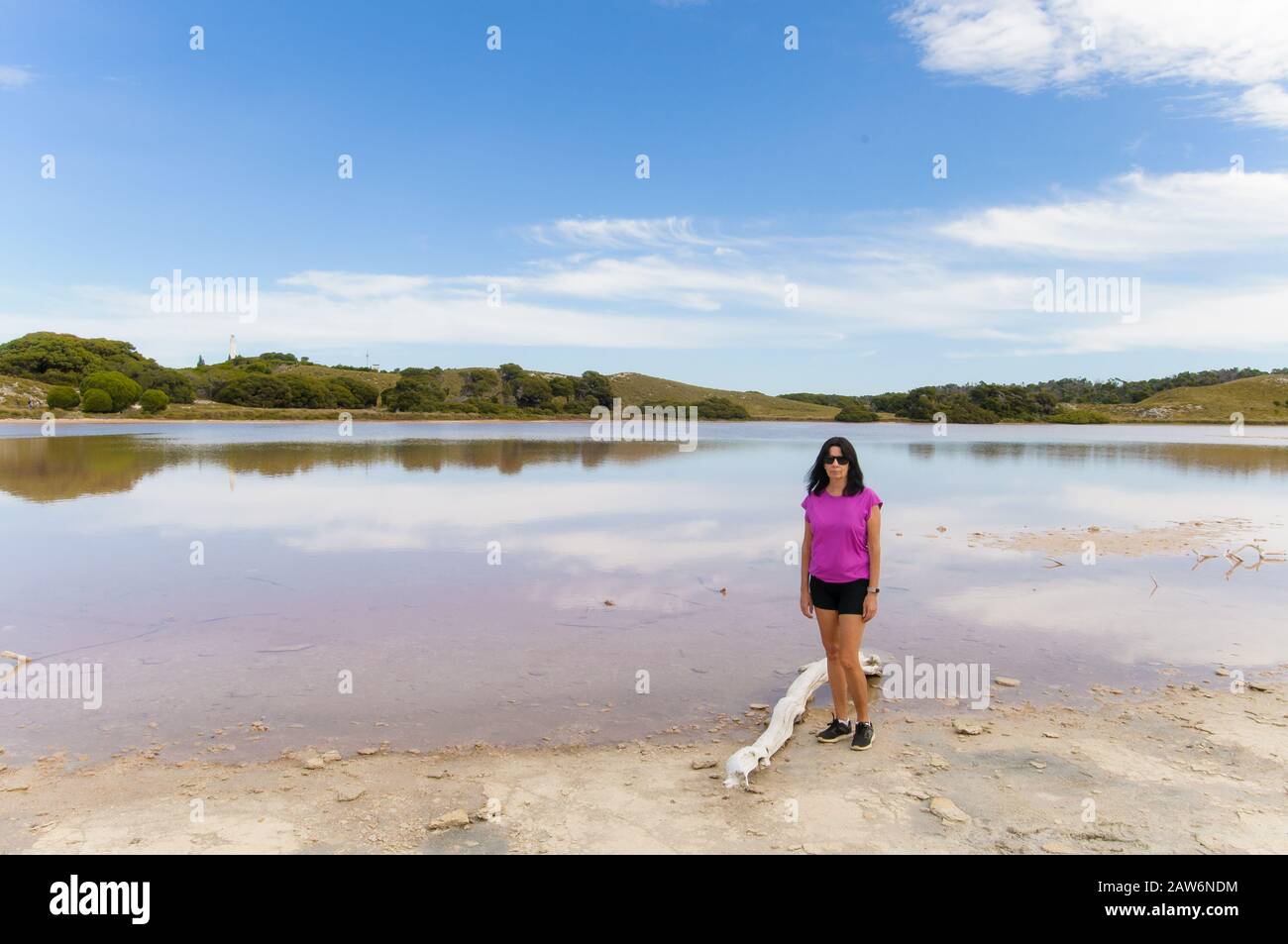 Ein weiblicher Wanderer macht eine Pause am Pink Lake Beach auf Rottnest Island in Western Australia. Stockfoto
