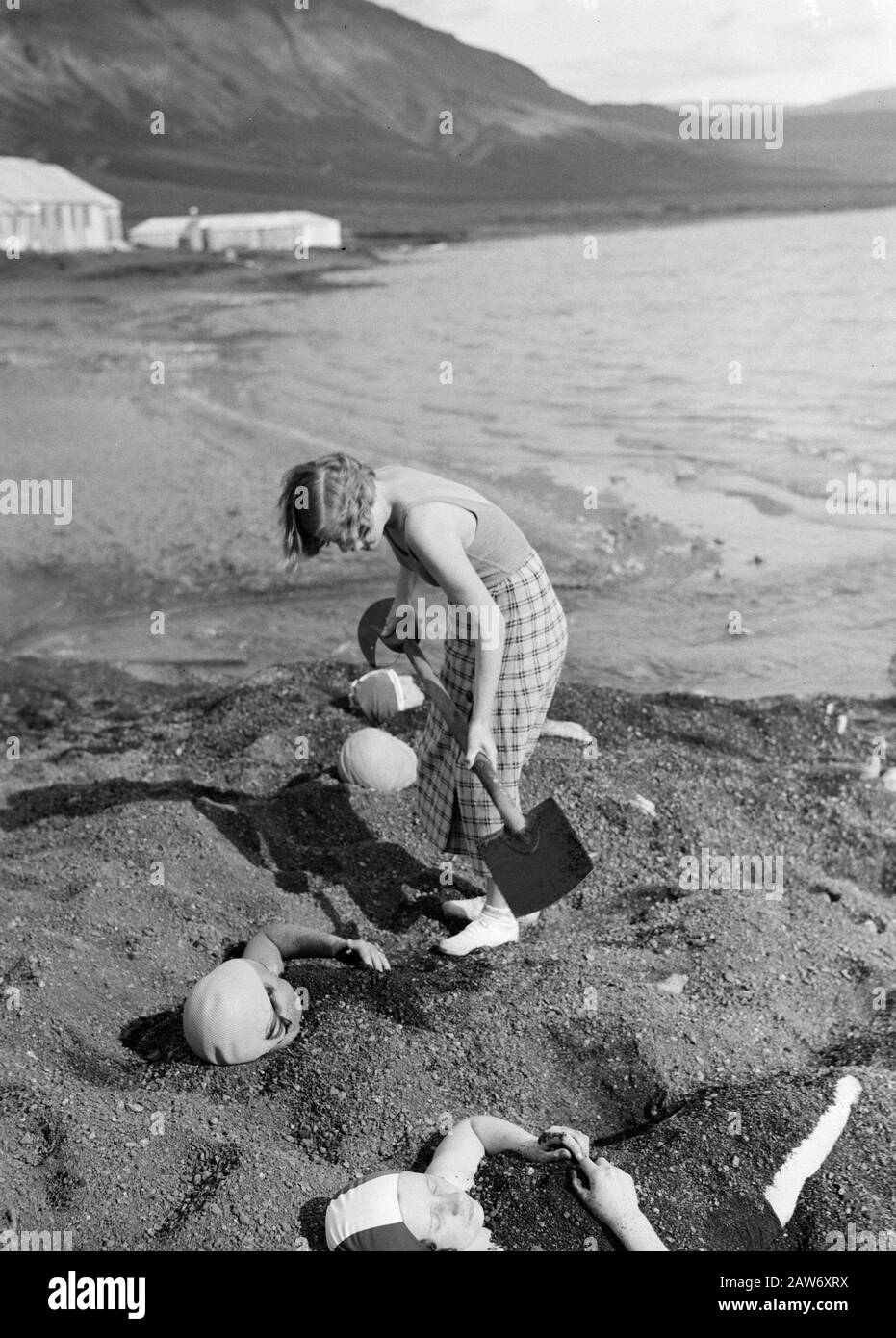 Island Laugarvatn. Mädchen begraben andere Mädchen unter heißer vulkanischer Asche am Ufer eines Sees mit warmem Wasser Datum: 1934 Ort: Island, Laugarvatn Schlüsselwörter: Landschaften, Mädchen, Seen, Zelte, Hitze, Wasser Stockfoto