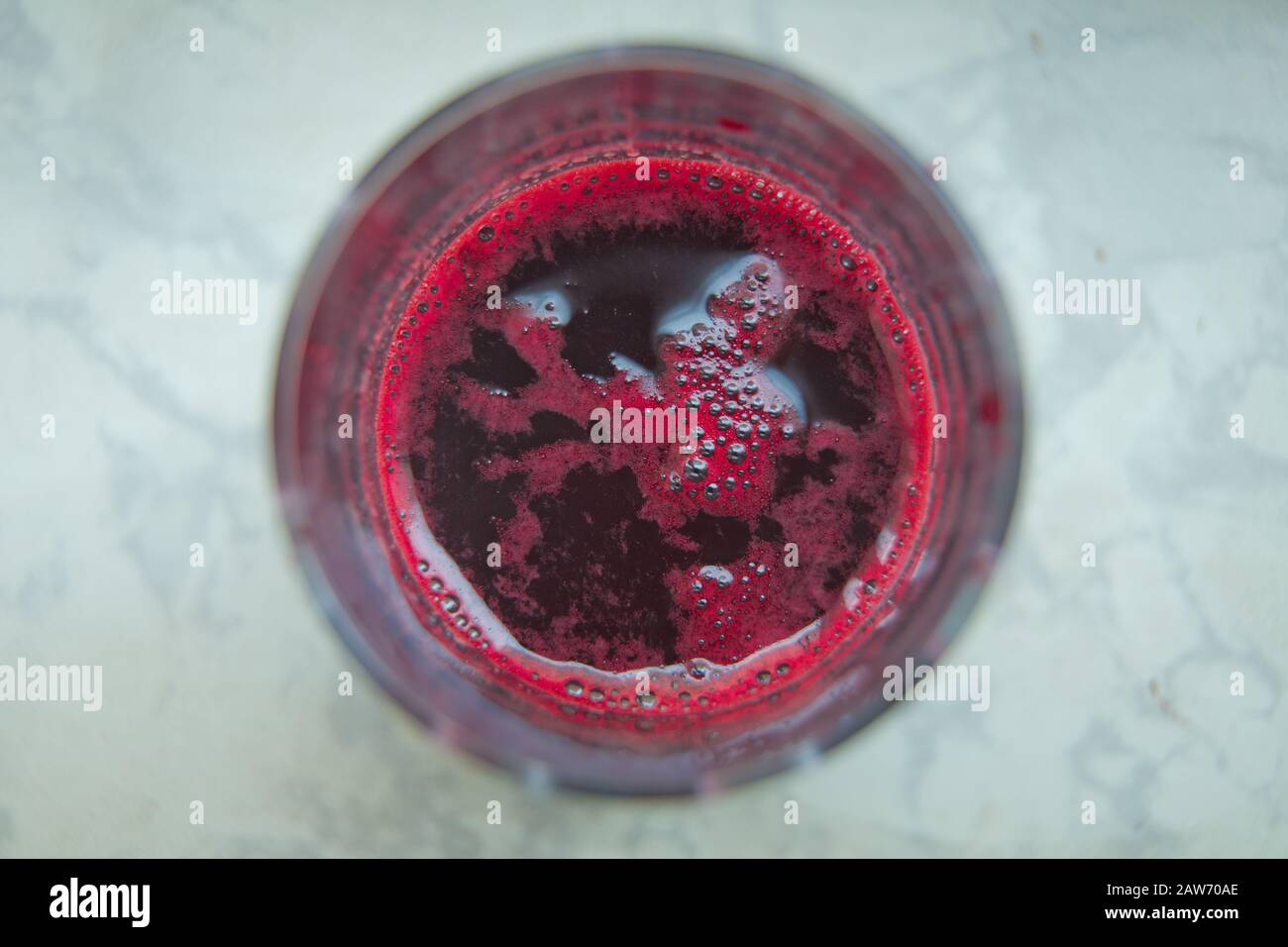 Frischer Saft, der gerade aus Beete hergestellt wurde, ein Glas, das aus Vogelperspektive auf weißem Hintergrund aufgenommen wurde. Glas Rübensaft isoliert auf weiß . Stockfoto