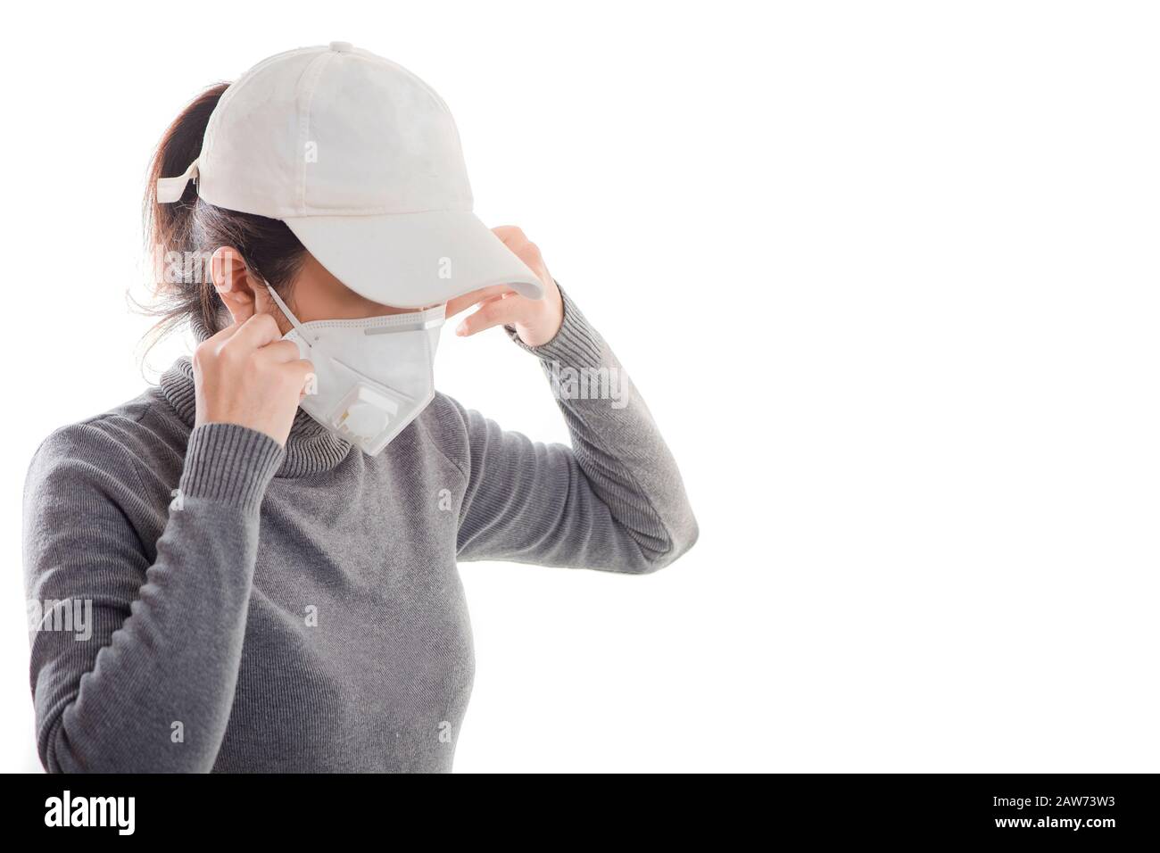 Frau mit grauem Hemd, die eine Maske trägt, die auf weißem Hintergrund isoliert ist. Die Förderung von Menschen verwendet Gesichtsmaske, um sich vor Virusinfektionen in Corona zu schützen Stockfoto
