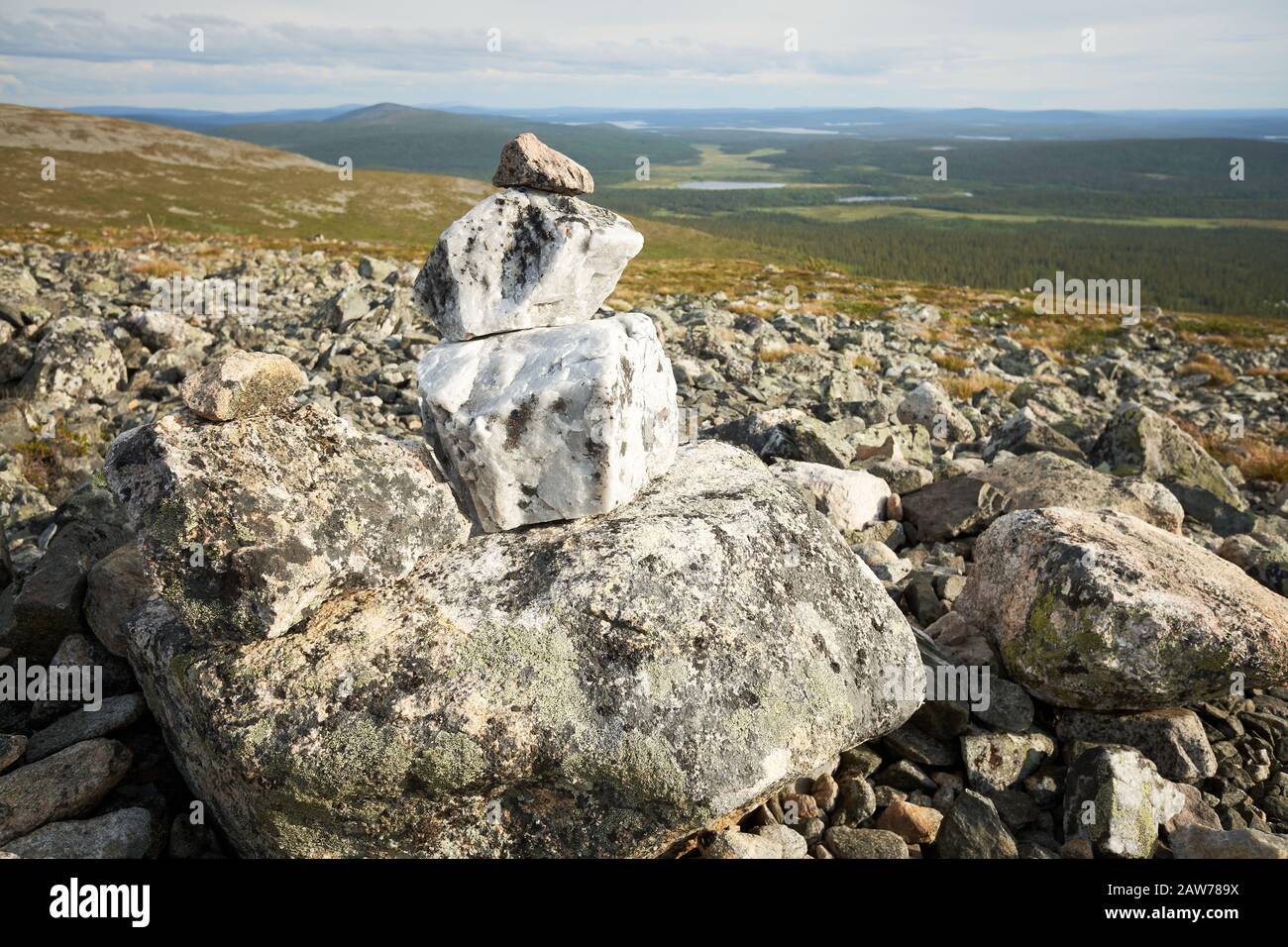 Schöner Steinstapel und Blick von einem fiel über Wälder, Seen und Sümpfe Lapplands. Pallas-Yllastunturi National Park, Finnland. Stockfoto