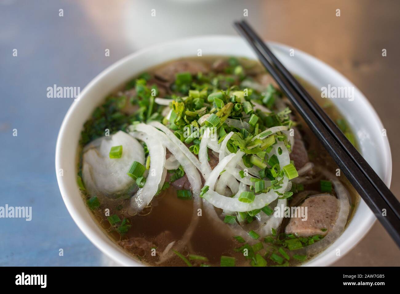 Nahaufnahme der traditionellen vietnamesischen Pho-Suppe in einer Schüssel mit Holzstäbchen Stockfoto