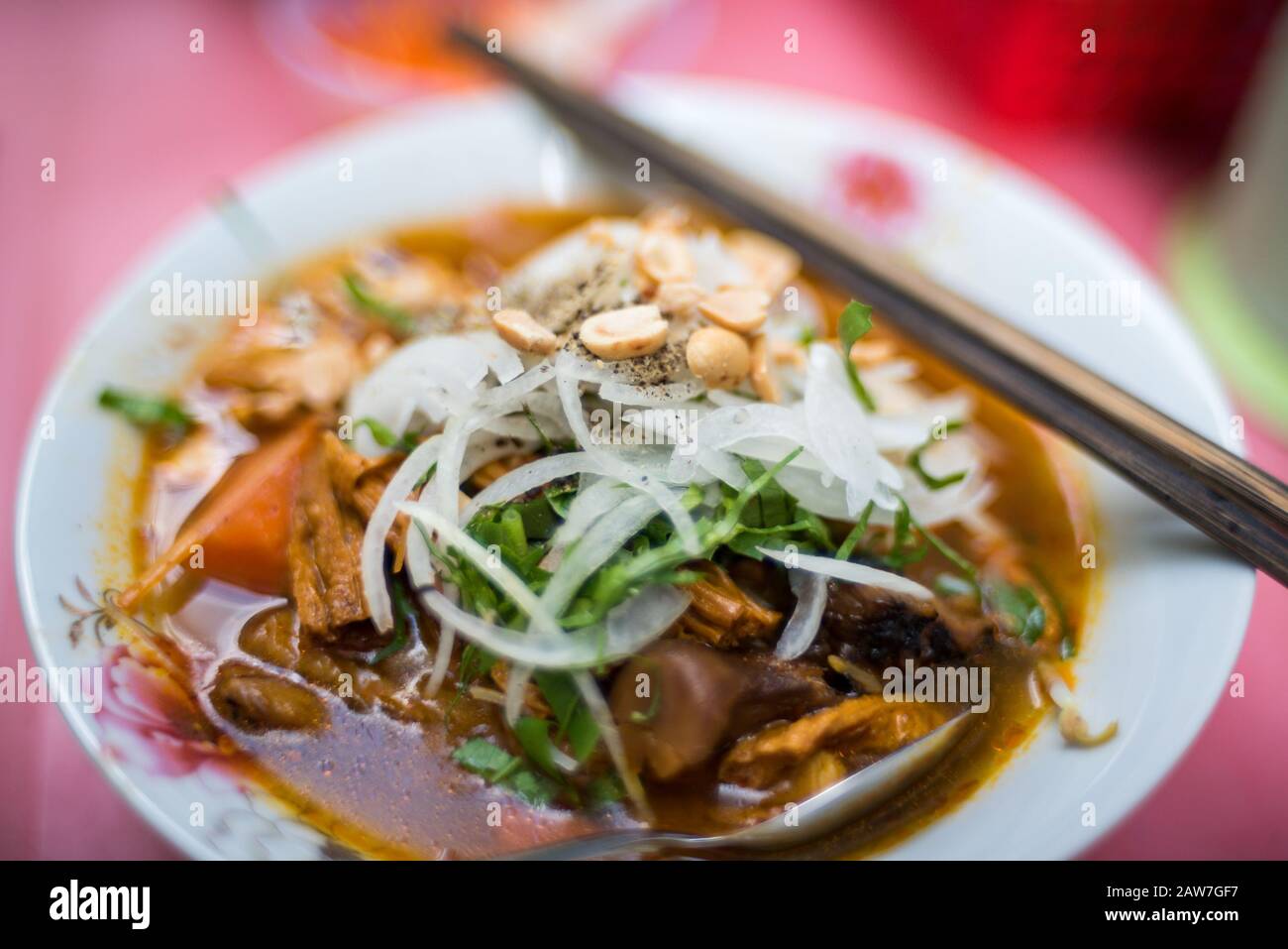 Nahaufnahme der traditionellen vietnamesischen Pho-Suppe in einer Schüssel mit Holzstäbchen. Authentische vietnamesische Küche in der Nähe Stockfoto