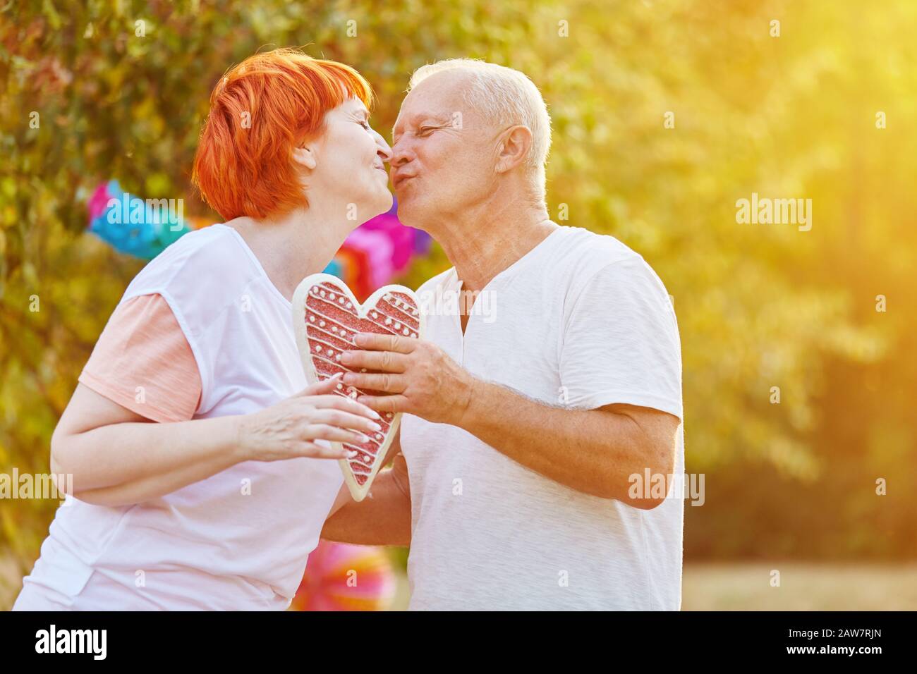 Liebespaar Senioren halten sich beim Küssen in der Natur ein Herz Stockfoto