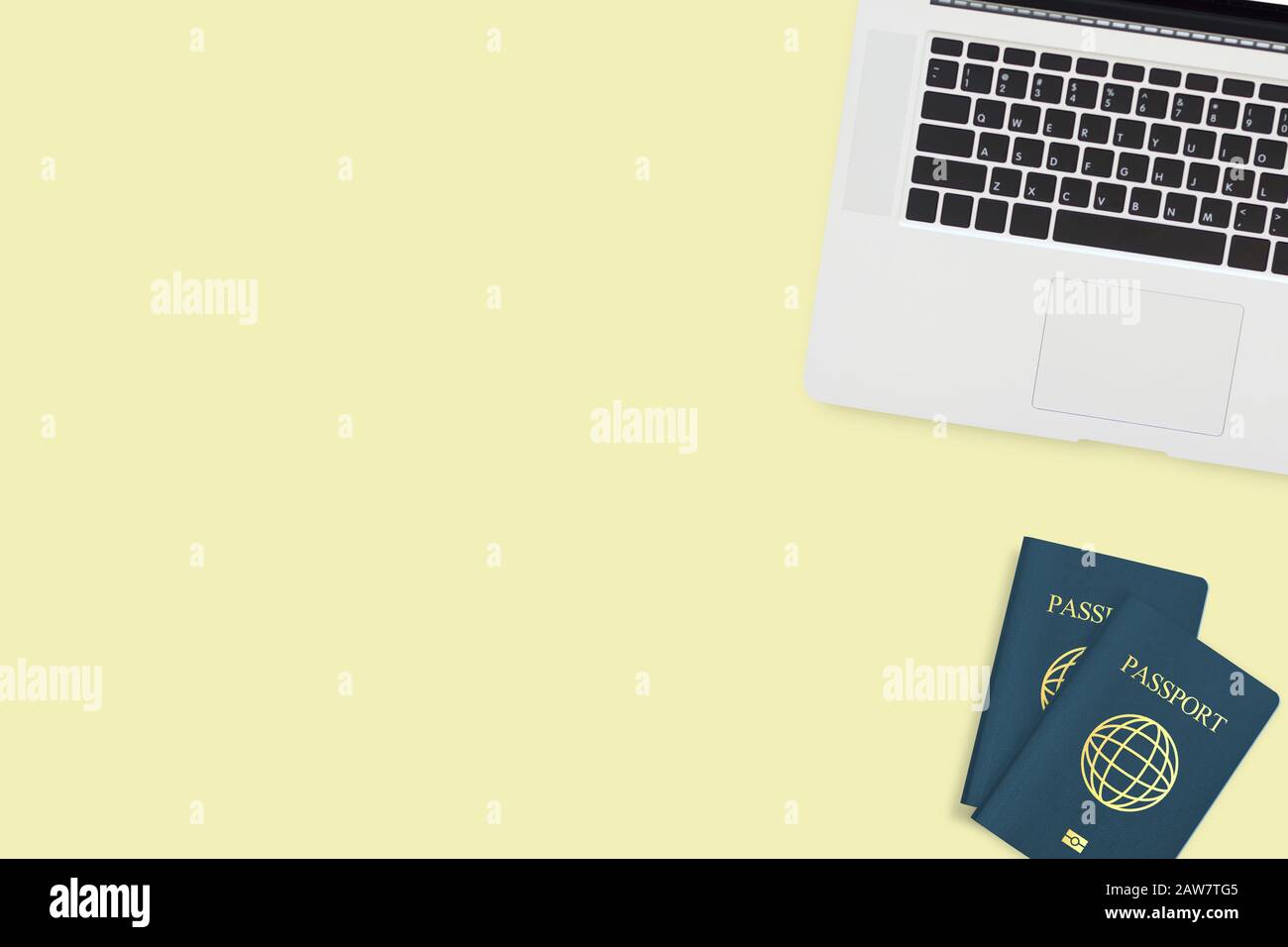 Flaches Lay aus zwei Pass-Computer-Laptops auf pastellgelbem Hintergrund mit Kopierraum. Reise-, Visa- und Urlaubskonzept Stockfoto