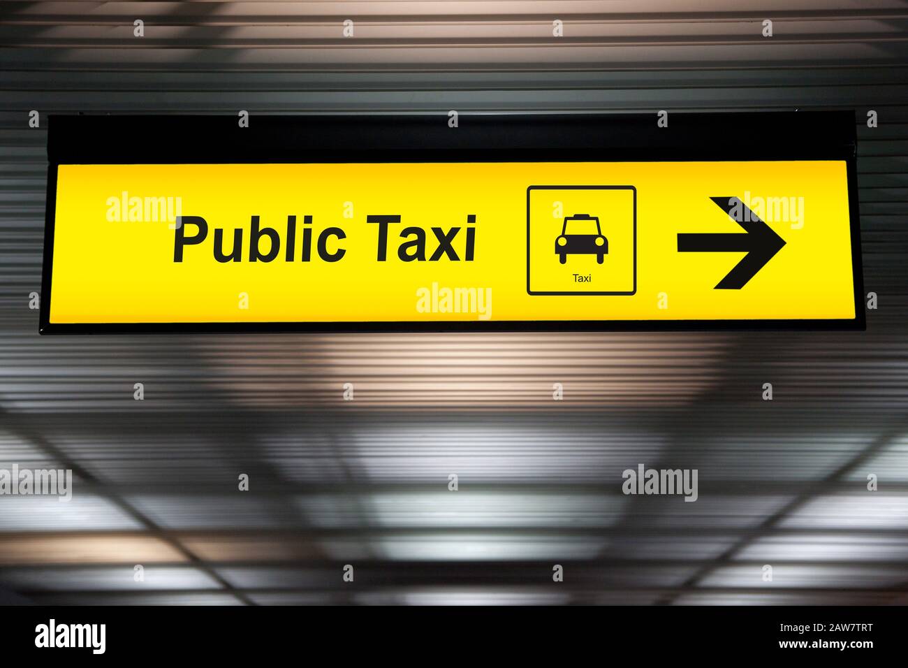 Schild mit dem öffentlichen Taxi mit Pfeil in Richtung für den Passagier zum Taxi-Park am Flughafenterminal. Taxi- und Transportkonzept. Stockfoto