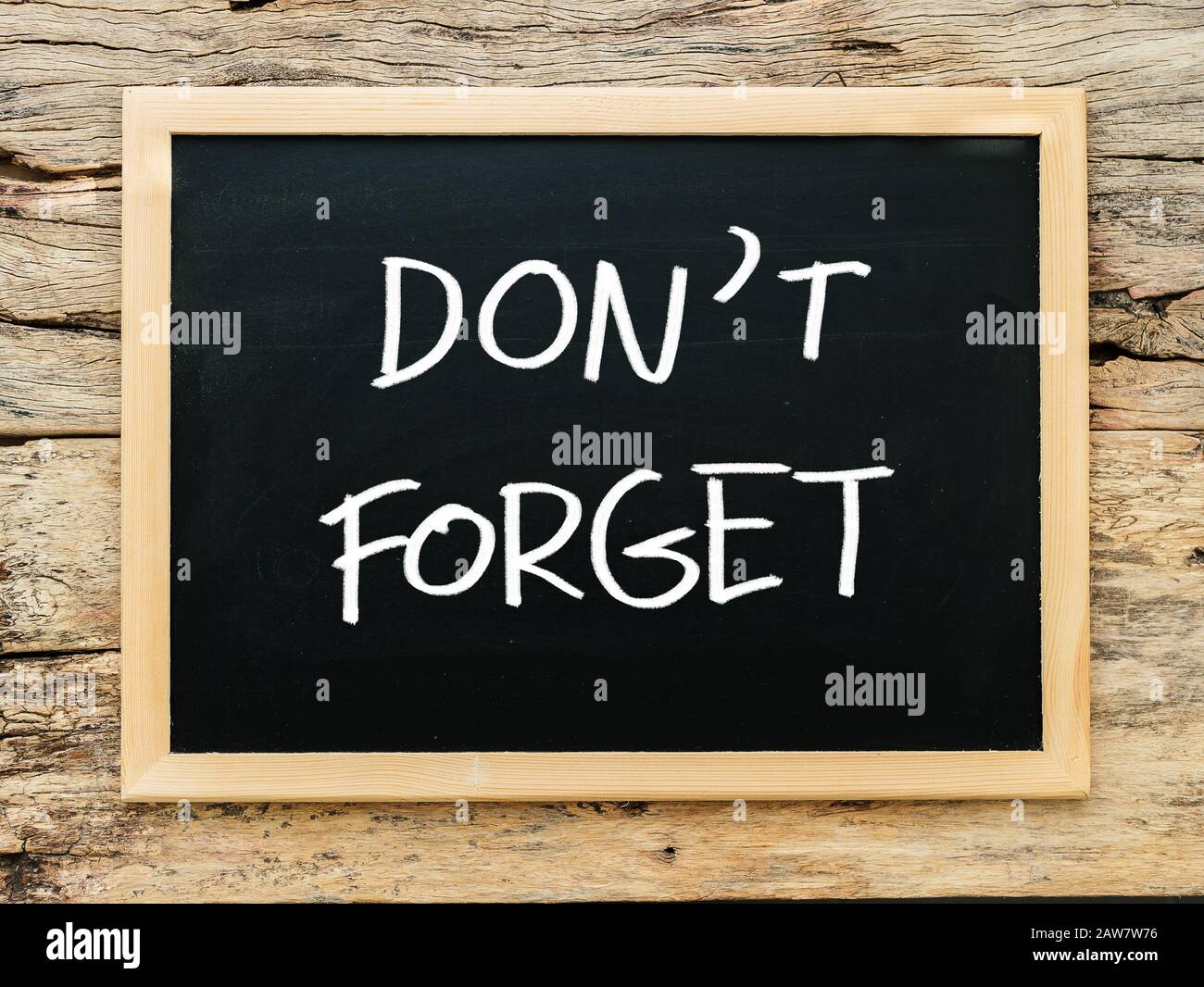 Text "nicht vergessen" auf schwarzem Schwarzen Brett mit Holzhintergrund. Besprechung erinnert an das Konzept der Erinnerungsnotizen Stockfoto