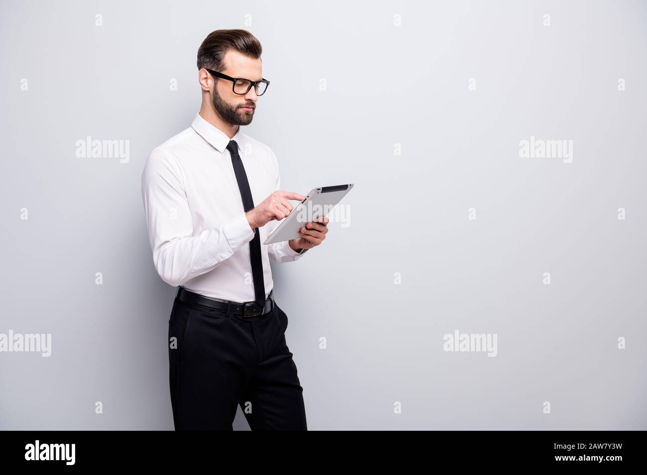Portrait des konzentrierten Rechtsanwalts verwenden Tablet-Suche Start-up News Workshop Lesen Sie Unternehmensdokumente tragen weiße schwarze Hosen Hose Hosen isoliert Stockfoto