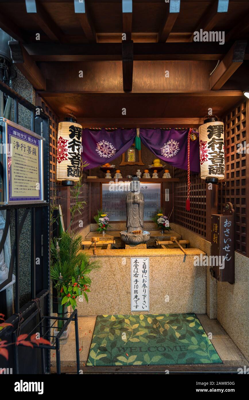 Tokio, japan - 02. januar 2020: Statue des Bodhisattva mit einem japanischen Tawashi-Pinsel in einem winzigen Schrein Tokios. Stockfoto