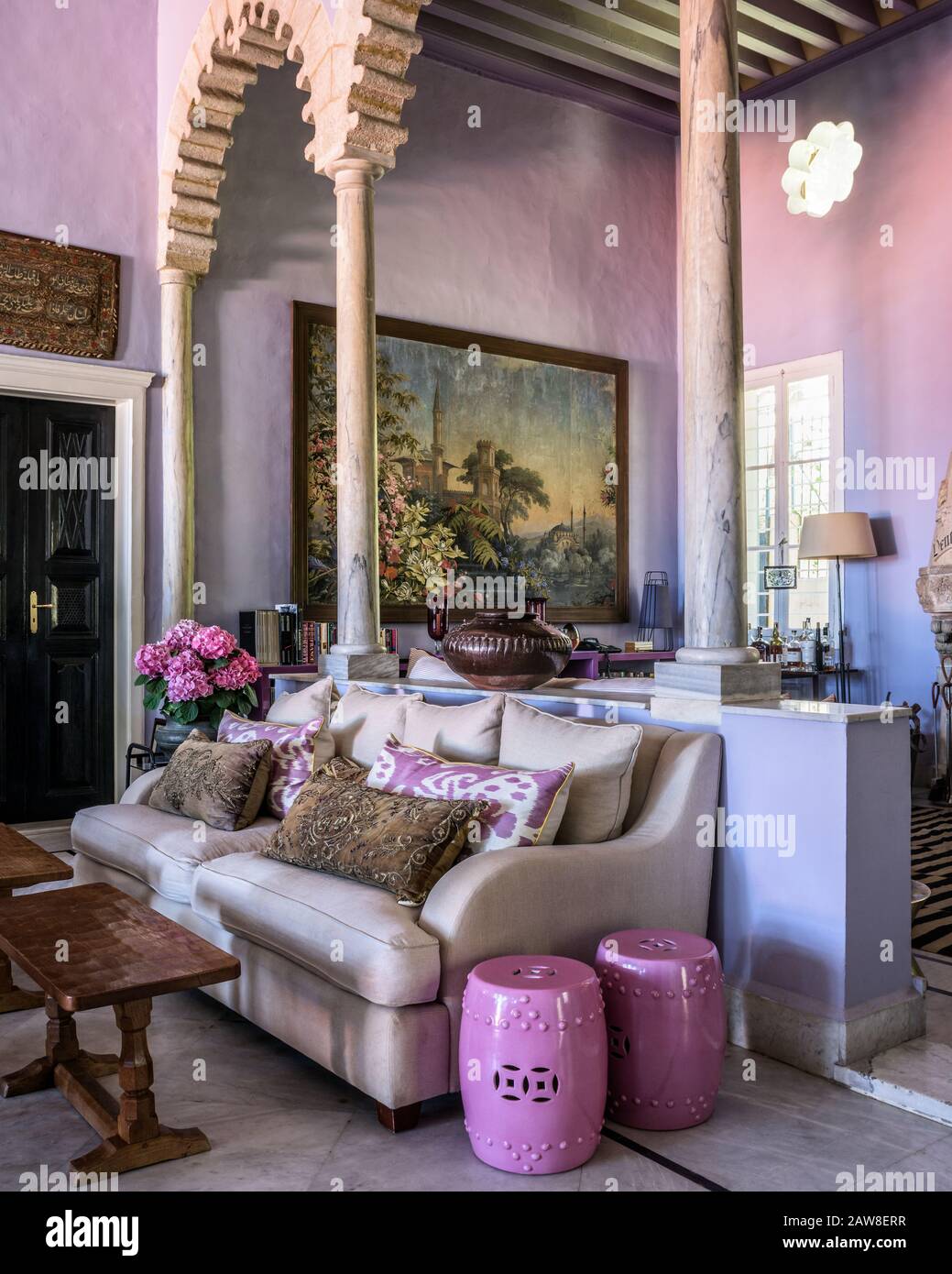 Sofa durch Säulen im femininen Wohnzimmer Stockfoto