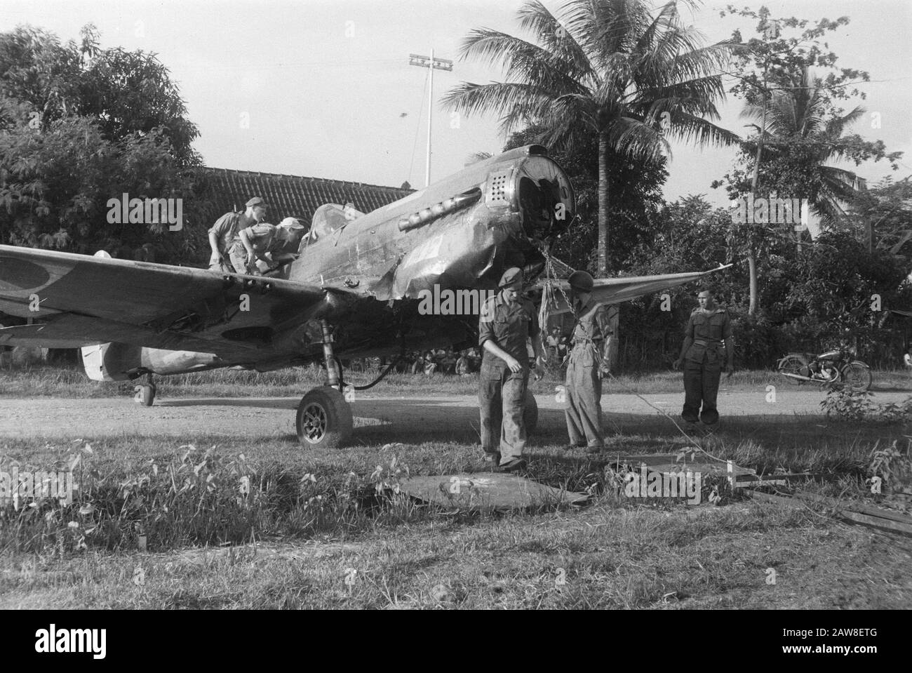 Notlandung eines Curtiss P40 in der Nähe von Solo Vor Kurzem landete ein Curtiss P40 Kampfflugzeug am Stadtrand von Solo. Da es keine Möglichkeit gab, die Einheit vor Ort zu befestigen und den Start auf dem mit Wasser bestückten Spielfeld zu unmöglich war, wurde das Flugzeug vom Militär an anderer Stelle geschleppt, um demontiert zu werden. Dragging the Aircraft to the Road Date: April 13, 1949 Ort: Bondowoso, Indonesien, Java, Niederländisch-Ostindien Stockfoto