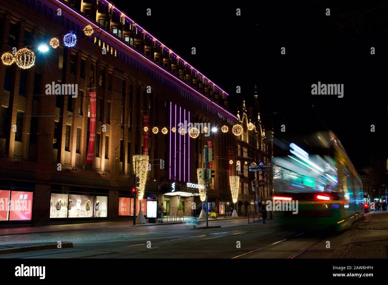 Helsinki, Finnland - 21. Januar 2020: Straßenbahnverkehr vor dem Kaufhaus Stockmann mit Winterlicht dekoriert. Stockfoto