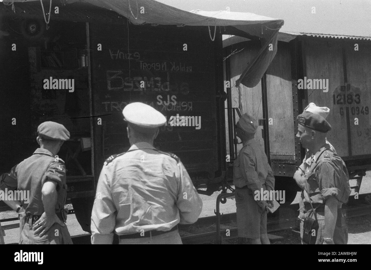 Beamte, die einen Güterwagen beobachten, der teilweise die "koloniale Verderbung" rückgängig machte, werden geschrieben. Der Wagen hat ein Vordach Datum: 10/01/1948 Standort: Indonesien Niederländische Ostindien Stockfoto
