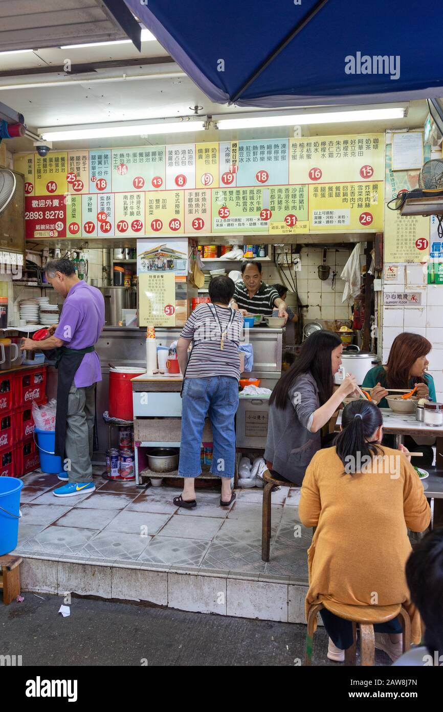 Straßennahrung in Asien; Menschen, die in einem Straßencafé oder einem Lebensmittelstall essen, Wan Chai District, Hongkong Asien - Beispiel für asiatischen Lebensstil Stockfoto
