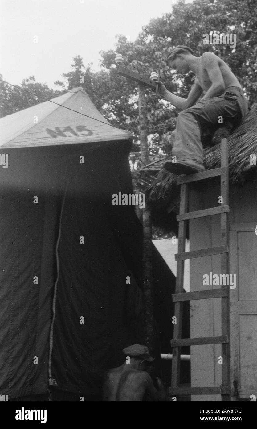 Fotos aus der Artikelartillerie machen Geschichte und Wohnen im Dschungel in der Zeitschrift Wapenbroeders Marihat. Armee-Camp. [Ein Soldat, der sich in einem kleinen Garten mit Palmen engagiert] Anmerkung: Marihat? Buntu Turunan? (Simalungun Nord-Sumatra). Das Regiment ist 5-11 R.I. Auf der Leinwand ist N.15. Datum: 14.November 1948 Ort: Indonesien Niederländische Ostindien Stockfoto