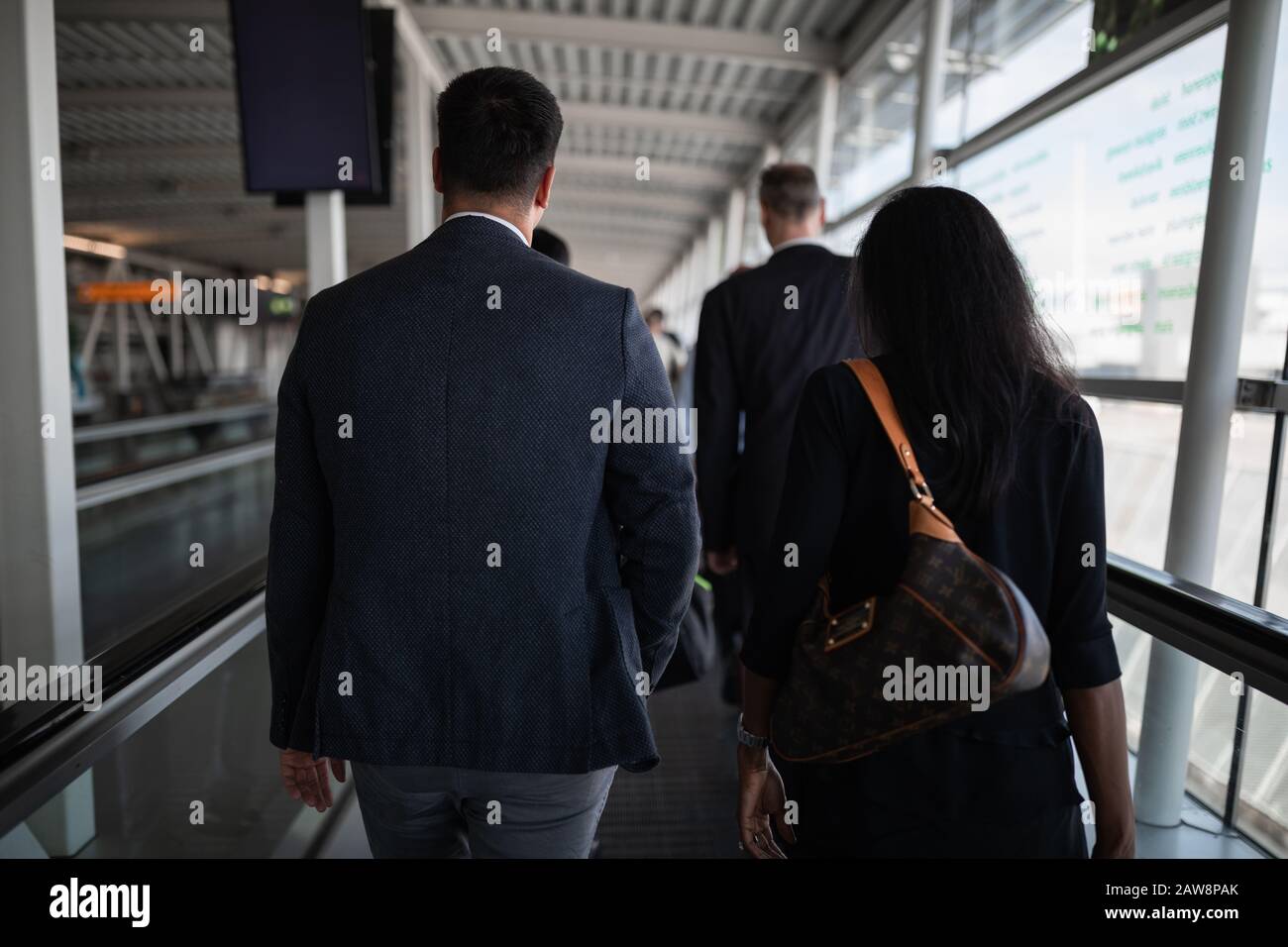 Männliche und weibliche Geschäftsreisende an einem internationalen Flughafen Stockfoto