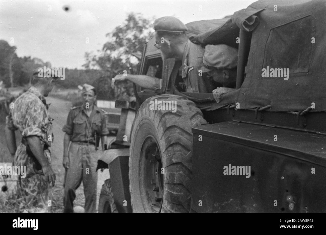 Besuch der US-Konsularmission in Palembang [Kommandeur J. W. R. Brueren Tiger (Kommandeur 7 (III) Bataillon Stoottroepen sprechen mit einem Leutnant, während die Insassen des gepanzerten Staplers C15TA zusehen] Datum: 17. Oktober 1947 Ort: Indonesien, Niederländische Ostindien, Palembang, Sumatra Stockfoto