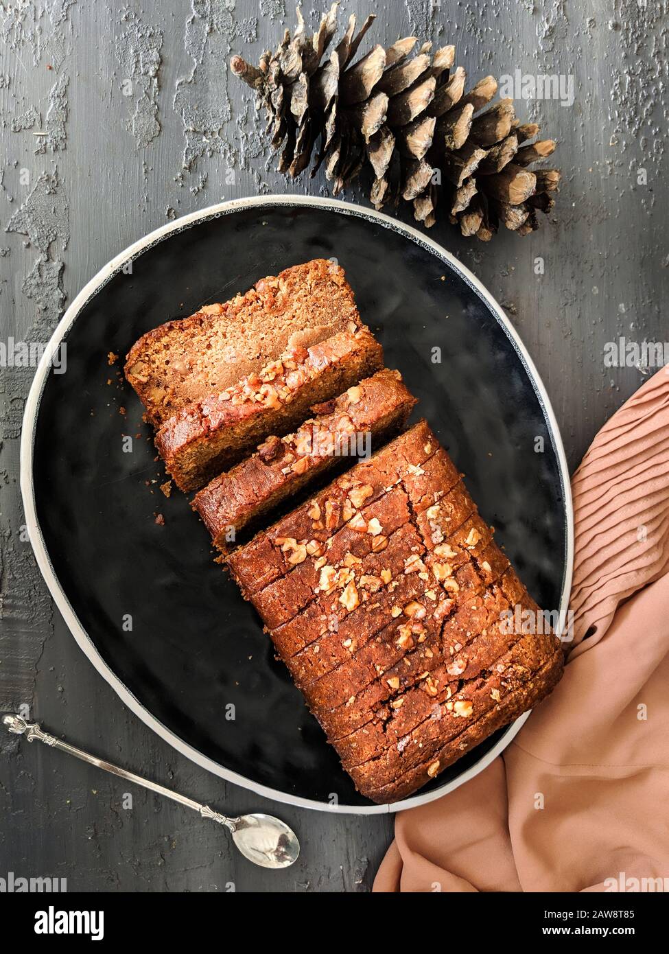 Karottenkuchen-Laib mit Hafer und Mandeln, in Scheiben geschnitten auf einem schwarzen Gericht, Draufsicht. Veganer, eggless Kuchen. Gesund, Ernährung, gesunde Lebensweise, Ernährung, gebacken. Stockfoto