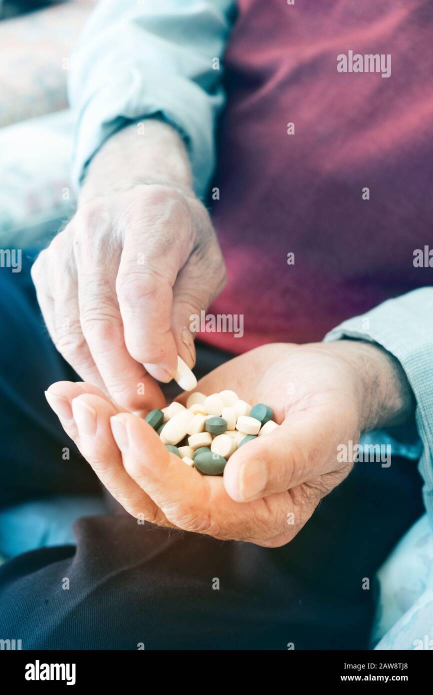 Nahaufnahme eines Senior kaukasischen Mann mit einem Stapel von verschiedenen Pillen in seiner Hand. Stockfoto