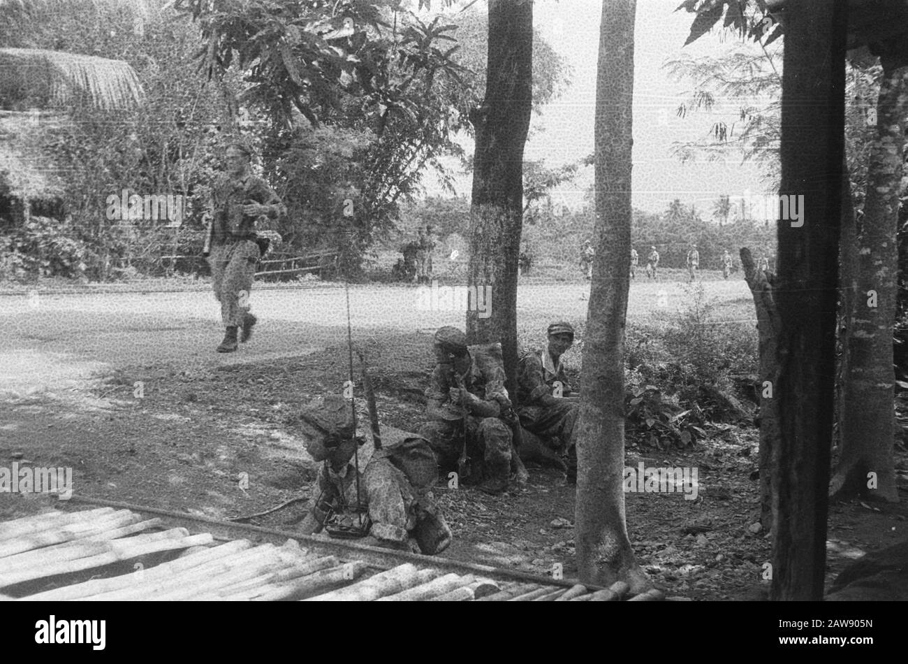 Eintritt und Vormarsch zum Yogya vom 1. Bis 15. Infanterieregiment [auf einer Straße sitzen drei Soldaten in Deckung. Auf der Straße ist ein Soldat, folgen Sie hinter ihm mehr] Datum: 19. Dezember 1948 Ort: Indonesien Niederländische Ostindien Stockfoto