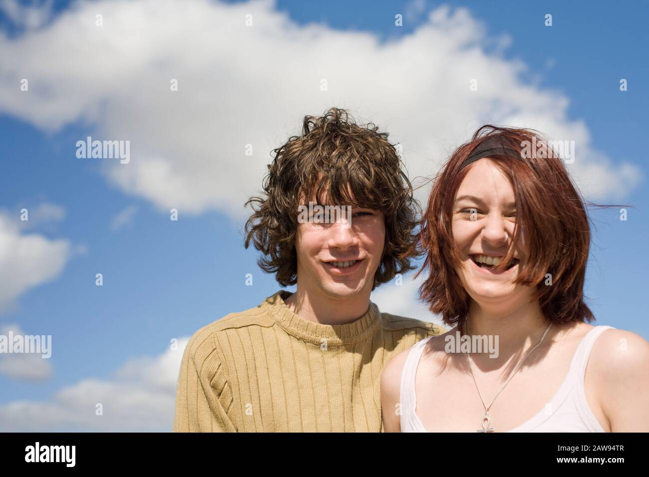 Ein Teenager-Paar lacht und lächelt draußen vor der Kamera Stockfoto