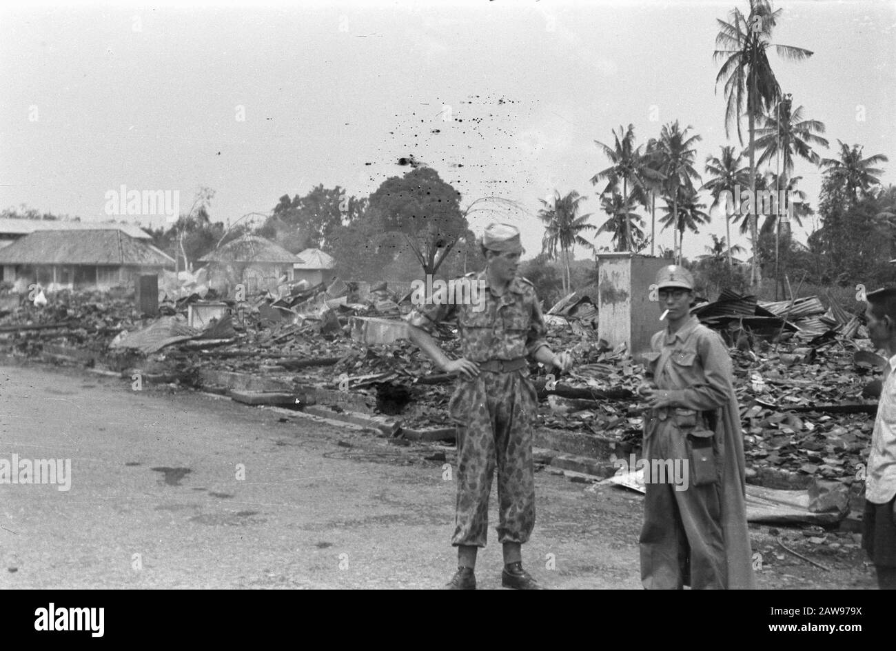 Report Deli Toea Lower Lande Soldat steht mit japanischem gefangenem? (Mit kap) für eine verwüstete Gemeinde Datum: Juli 1947 Ort: Indonesien, Niederländisch-Ostindien, Sumatra Stockfoto