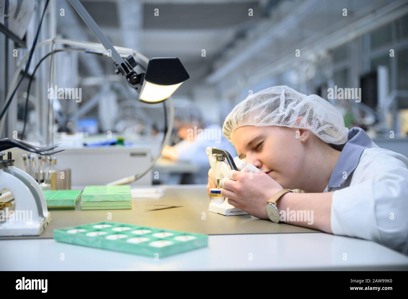 Schramberg, Deutschland. Februar 2020. Ein Mitarbeiter in der Produktionsabteilung des Uhrenherstellers Junghans steckt eine Hand in eine Uhr. Credit: Sebastian Gollnow / dpa / Alamy Live News Stockfoto