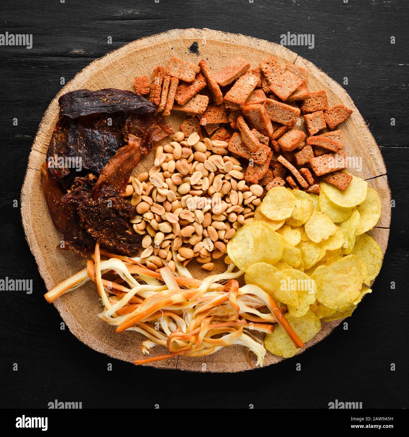 Snacks zum Bier. Pommes, gesalzene Nüsse, getrocknetes Fischfleisch. Auf dem alten Hintergrund. Freier Kopierspeicher. Stockfoto