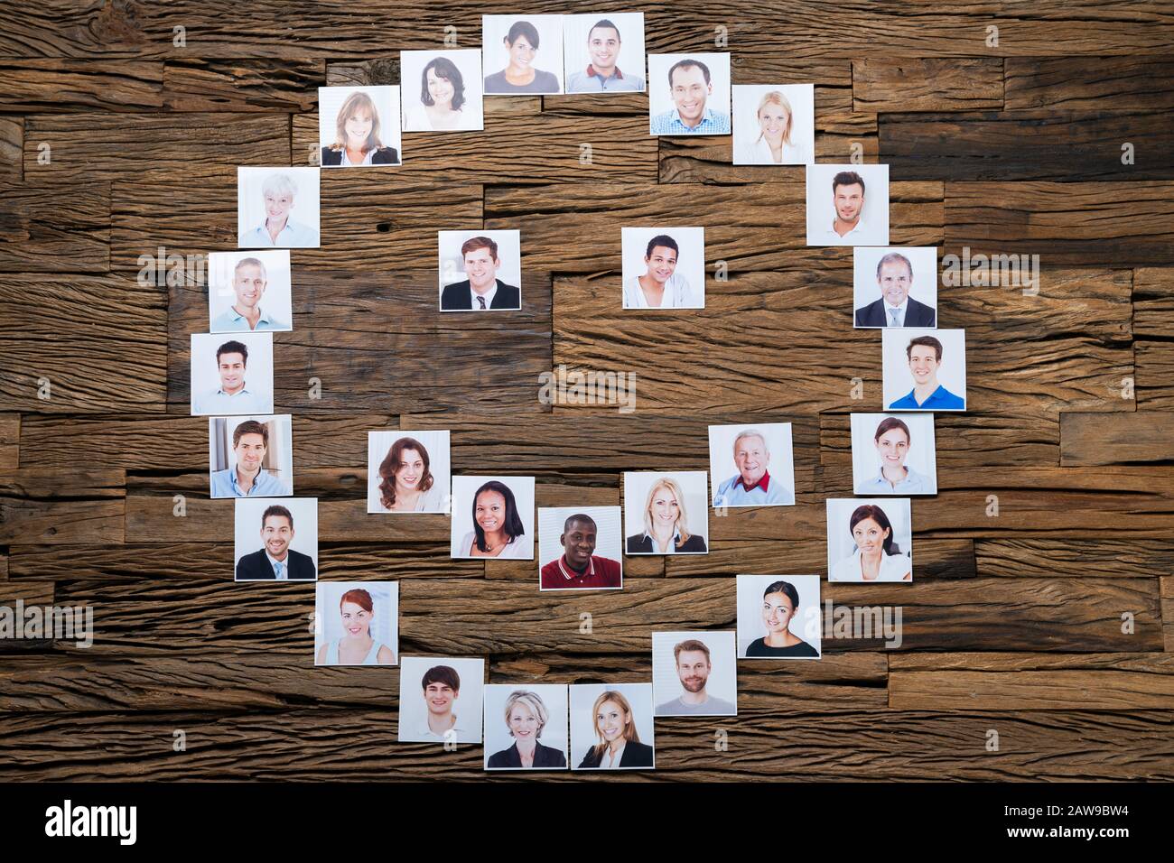 Person Lächelnde Ikone Aus Fotos Von Menschen Auf Holztisch Stockfoto