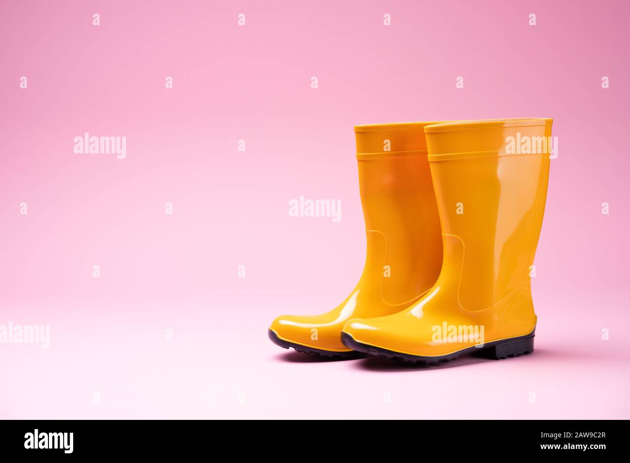 Foto Der Gelben Gummistiefel Auf Pinkfarbenem Hintergrund Stockfoto